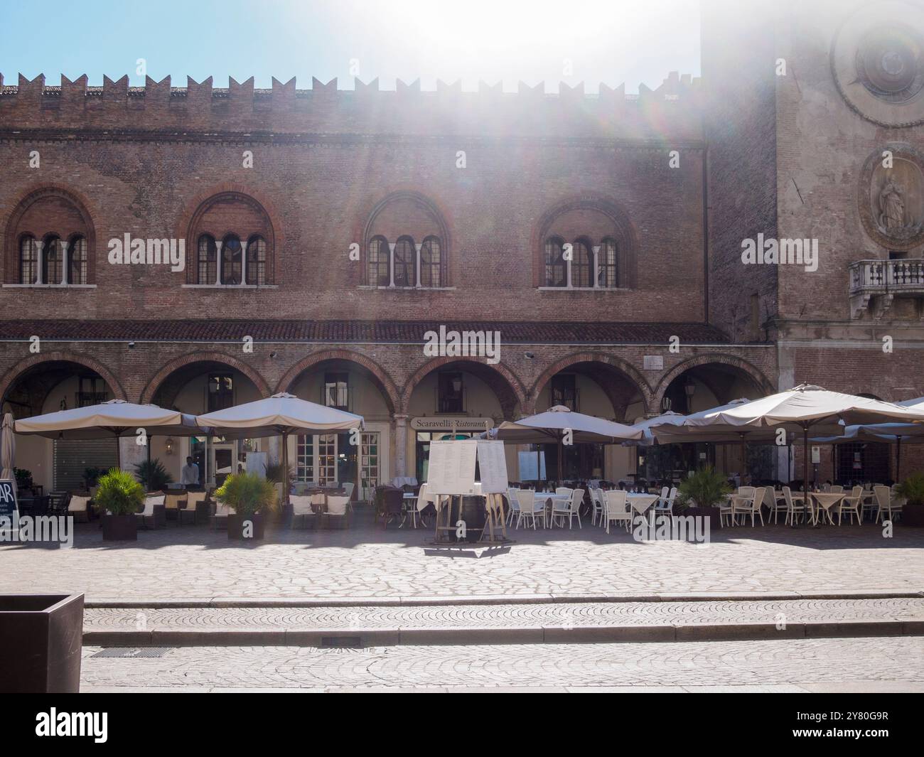 Mantoue, Italie 30 septembre 2024 le soleil brille sur les tables vides d'un restaurant à piazza delle erbe, mantoue, lombardie, italie Banque D'Images