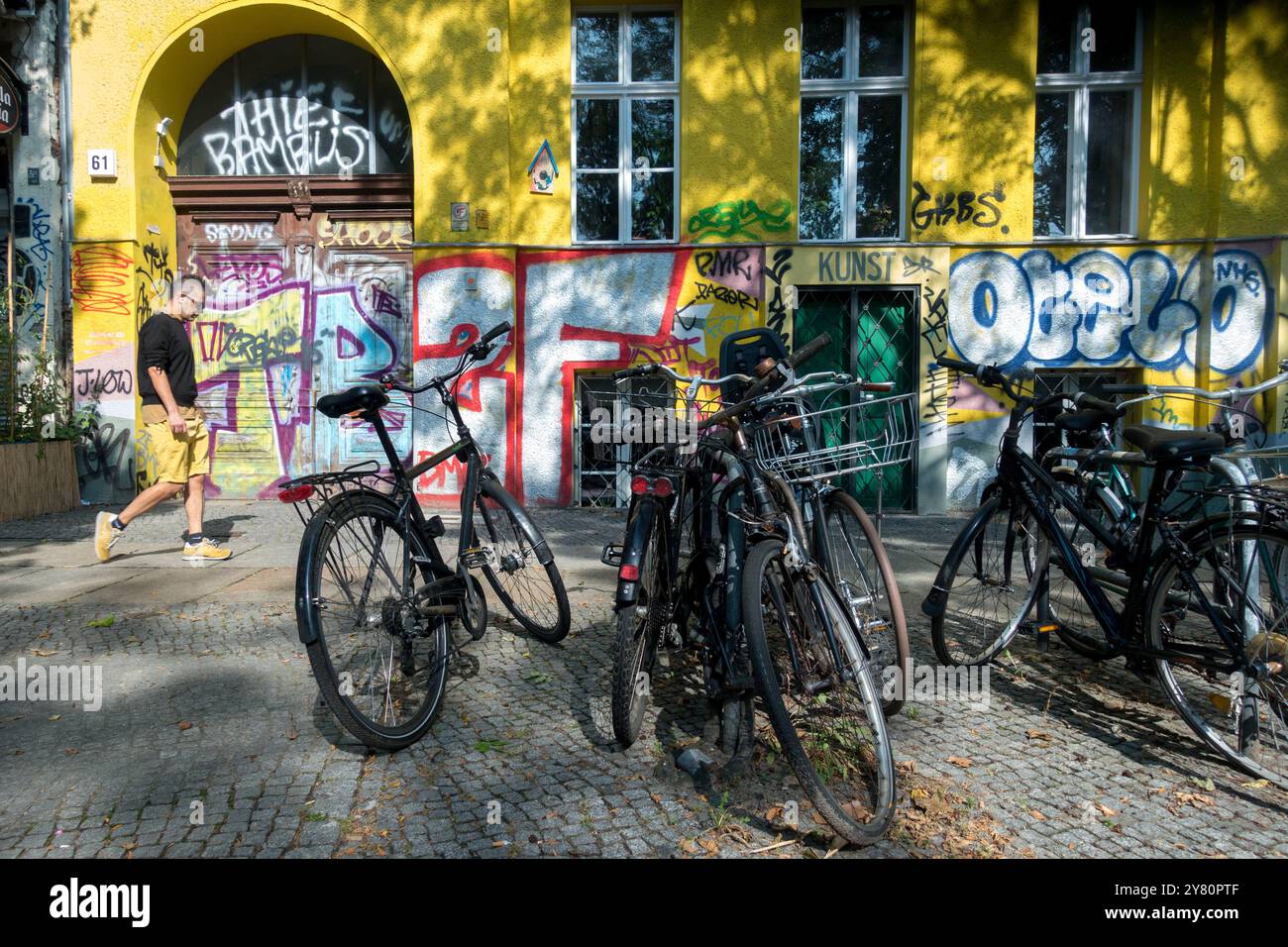 Berlin homme marchant et vélos garés sur la rue colorée City Town District Kreuzberg Berlin Allemagne Europe Banque D'Images