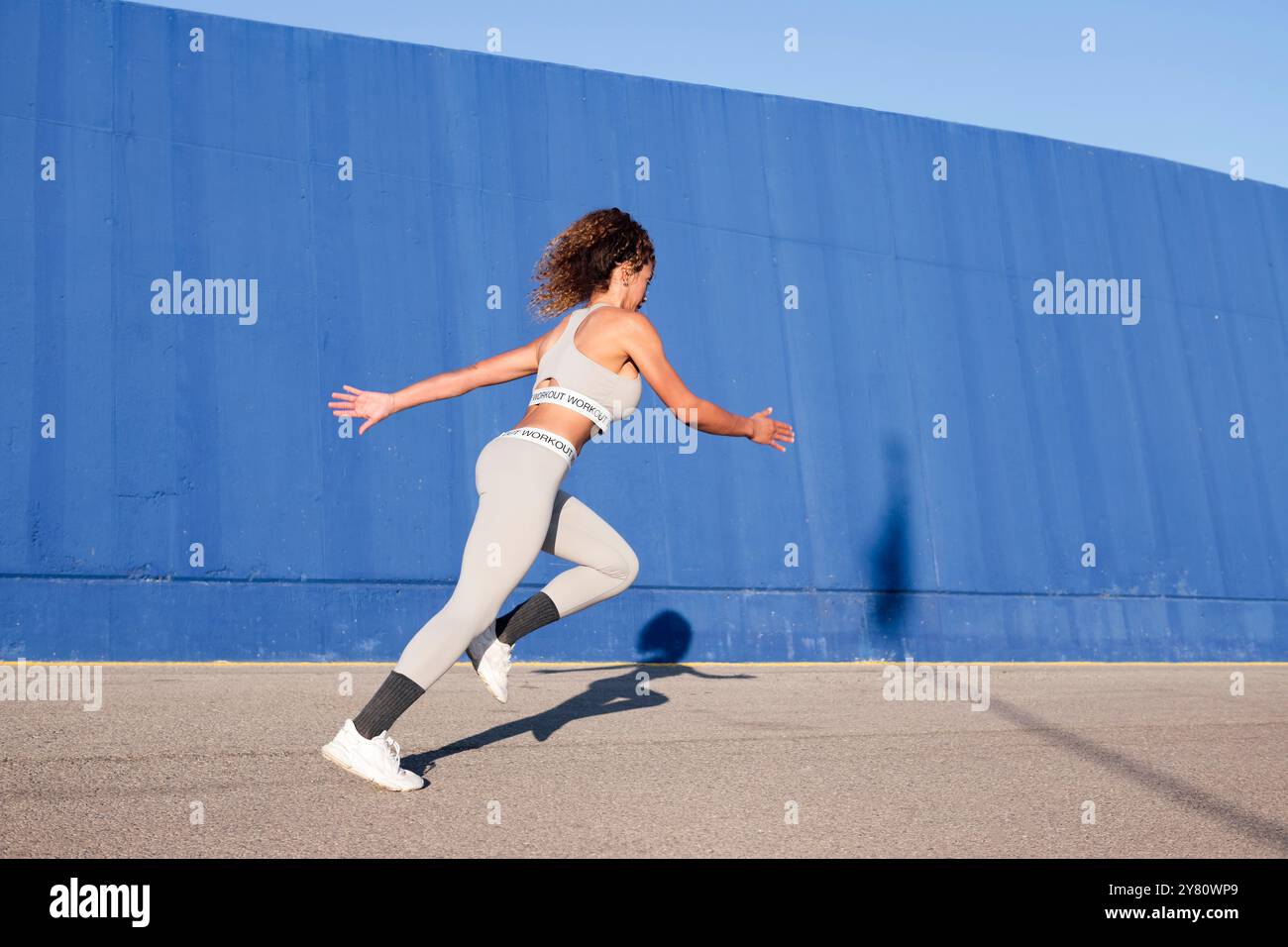 coureuse féminine concentrée en sprint sur le trottoir Banque D'Images