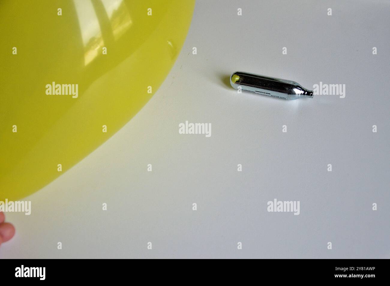 France. 1er octobre 2024. Dans cette illustration photo, un ballon jaune gonflé et une cartouche d'oxyde nitreux reposent sur une table blanche. L'oxyde nitreux, surnommé « gaz riant », est un nouveau médicament qui attire de plus en plus d'adolescents. Crédit : SOPA images Limited/Alamy Live News Banque D'Images