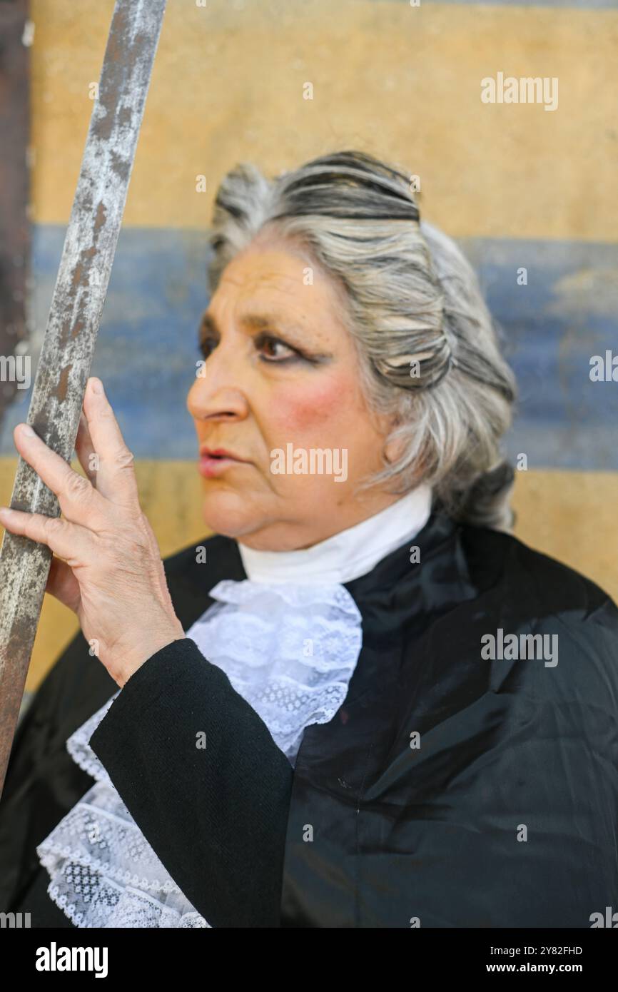 Juge senior profondément dans la pensée, caressant doucement une épée, symbolisant l'injustice, la corruption et l'abus de pouvoir dans le système juridique Banque D'Images