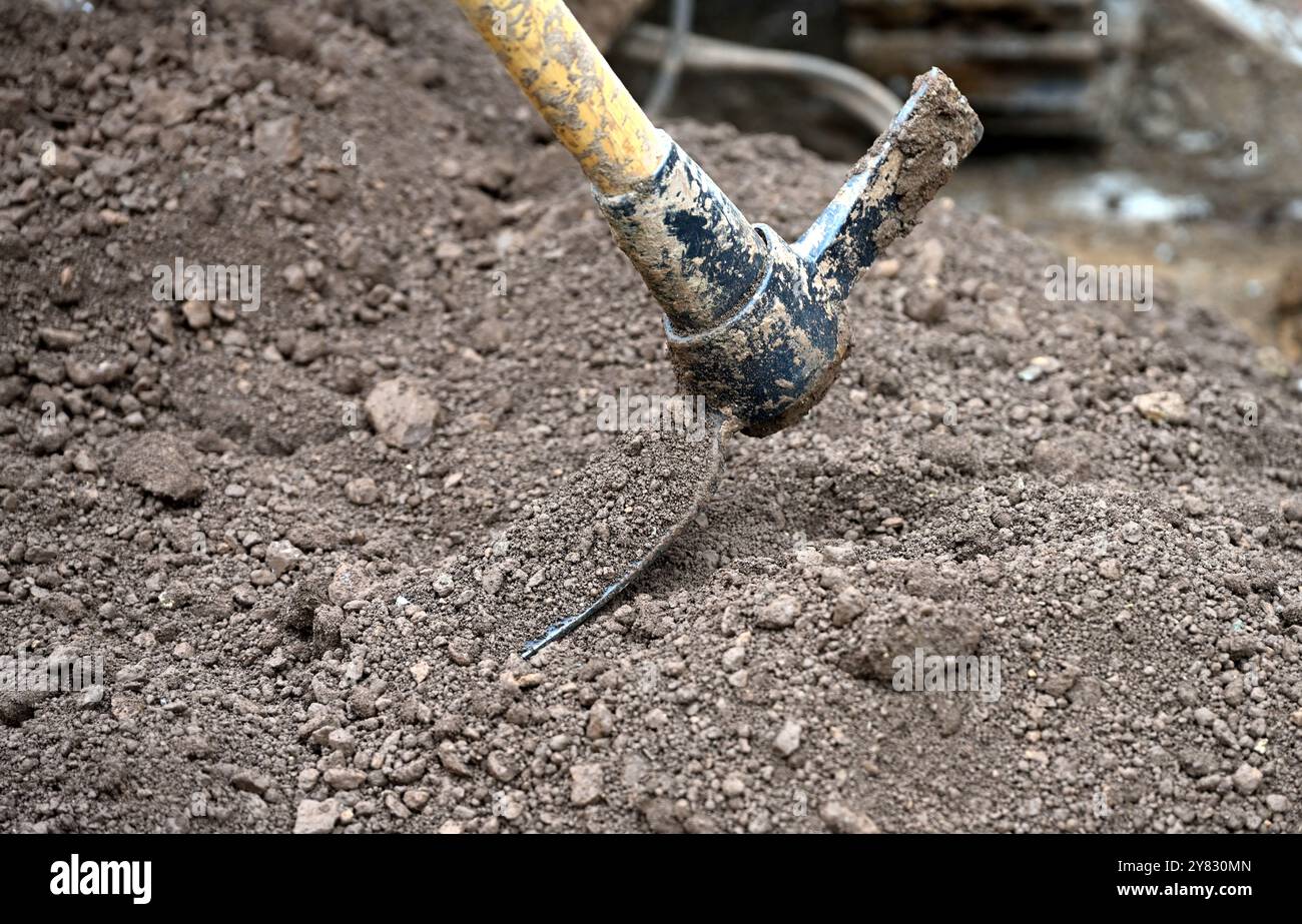 Mattock utilisé pour déplacer le sol d'un site de forage à vis sans fin Banque D'Images