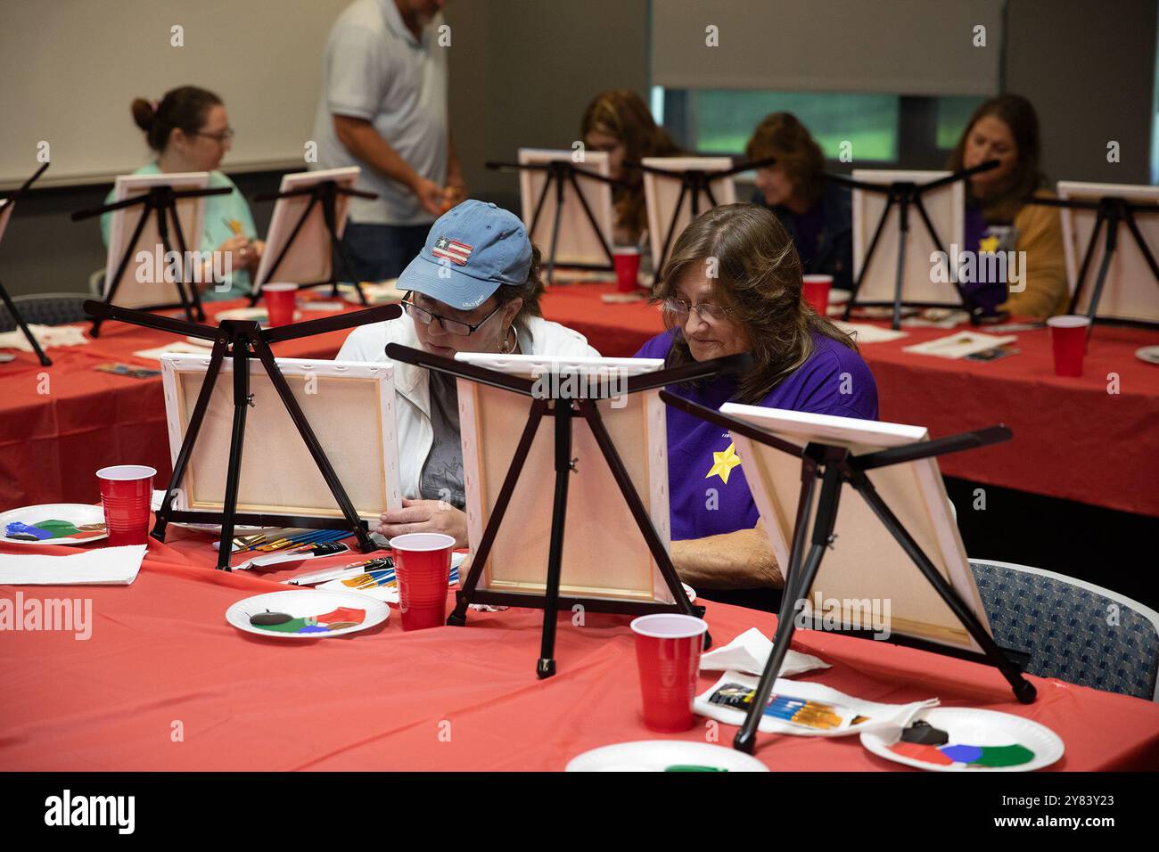 Kingwood, Virginie occidentale, États-Unis. 28 septembre 2024. (De gauche à droite) amie Gullifer et Sue VanGiesen peignent leurs toiles lors d'un cours de peinture tenu pendant la retraite annuelle des familles Gold Star de la Garde nationale de Virginie-occidentale le 28 septembre 2024 au Camp Dawson, à Kingwood, en Virginie-occidentale. Depuis sa première désignation par le Congrès en 1936, le dernier dimanche de septembre a été reconnu comme la Fête des mères étoile d'or et en 2012 a été déclaré âGold Fête des mères étoiles et des familles. La Garde nationale de Virginie-occidentale accueille des familles Gold Star de Virginie-occidentale et de Pennsylvanie qui se réunissent chaque année au C. Banque D'Images