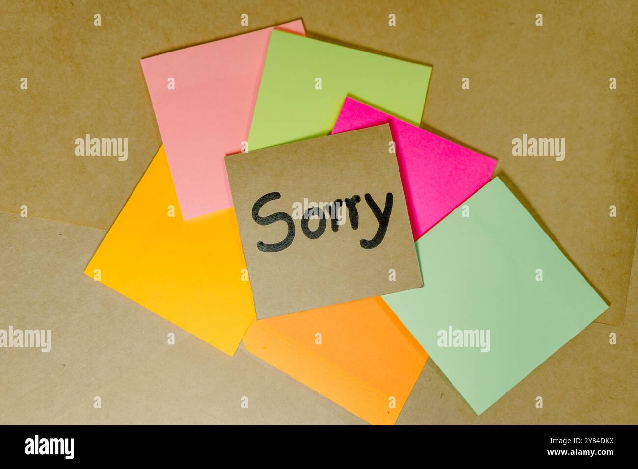 Phrase de pardon écrite sur du carton recyclé avec un fond de cahier ligné et des notes adhésives Banque D'Images