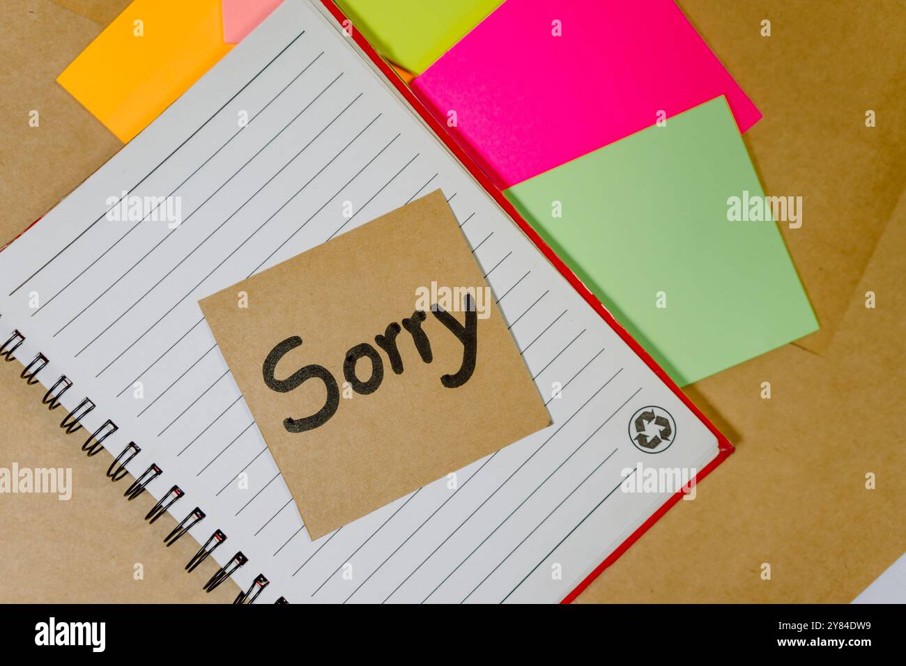 Phrase de pardon écrite sur du carton recyclé avec un fond de cahier ligné et des notes adhésives Banque D'Images