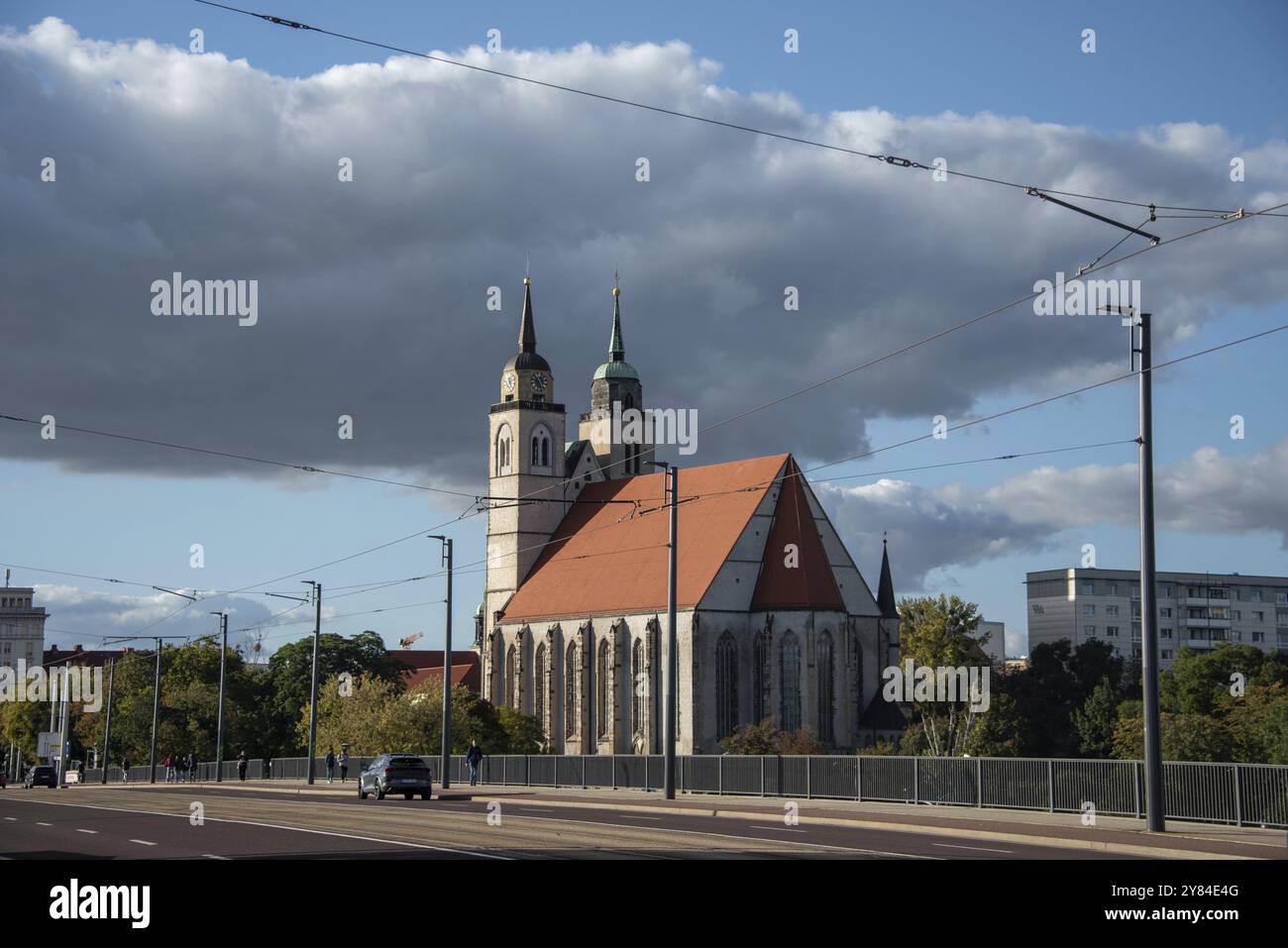 Gros plan de l'église Saint-Jean avec deux tours et un toit rouge, à côté d'une rue et sous un ciel avec des nuages, Magdebourg, Saxe-Anhalt, Allemagne, Europe Banque D'Images