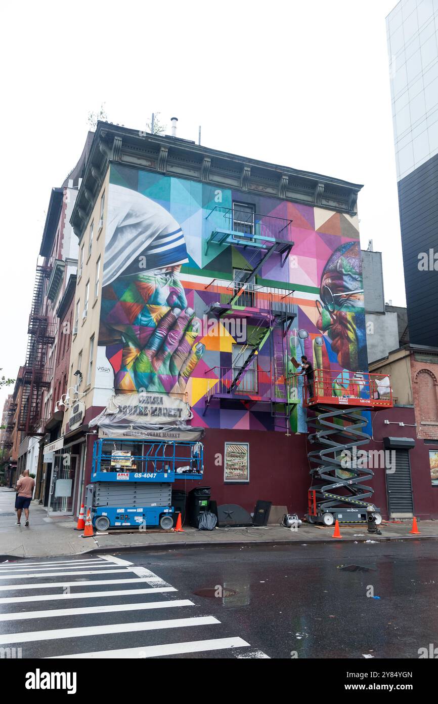 New York, New York, 19 août 2018 : Eduardo Kobra peint une fresque avec mère Teresa et Mahatma Ghandi sur le côté du marché de Chelsea Square le 10 Banque D'Images