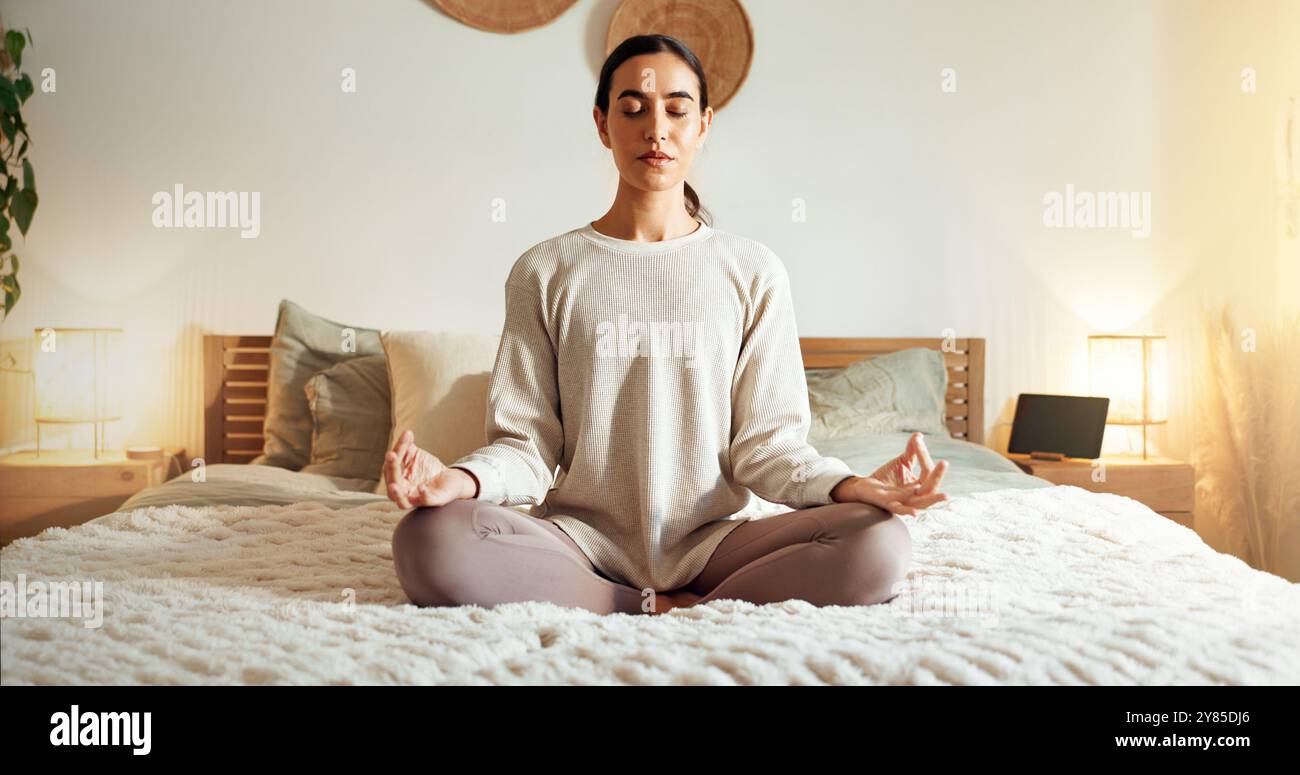 Calme, méditation et femme dans la chambre, paix et détente sur le lit, spirituel et illumination dans la maison. État d'esprit, zen et santé émotionnelle avec chakra Banque D'Images