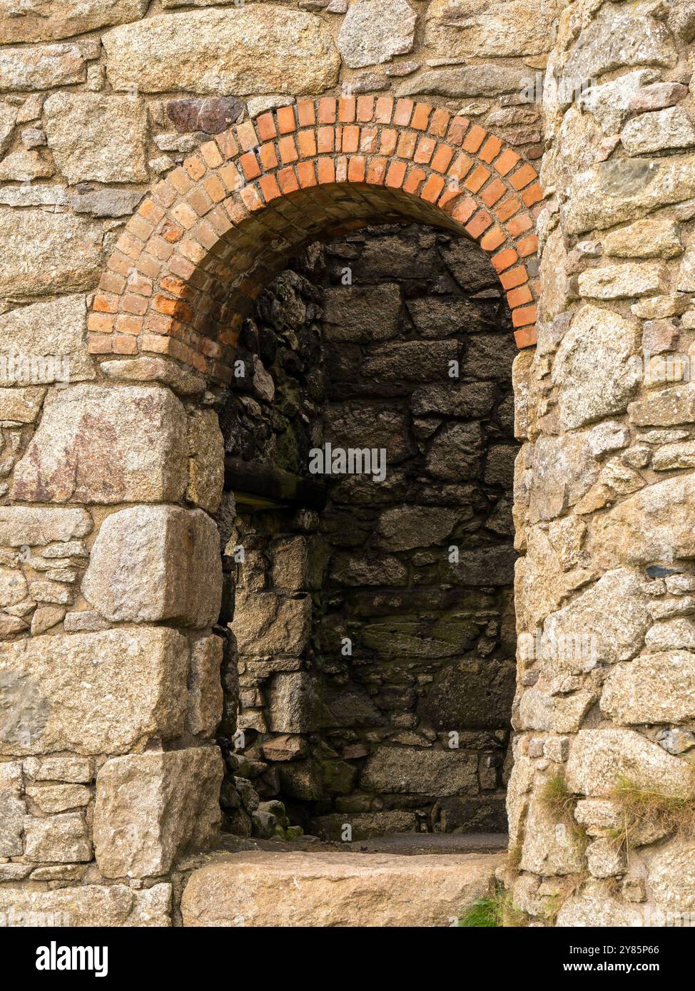 Arc romain dans le mur de la vieille maison de moteur de mine d'étain de Cornish construit à partir de briques rouges et de granit de Cornish, Botallack, Land's End, Cornwall, Angleterre, ROYAUME-UNI. Banque D'Images