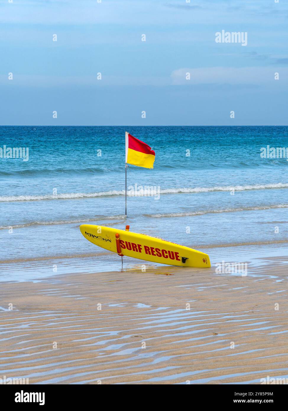 Planche de surf de sauvetage jaune et drapeau d'avertissement jaune et rouge de sauveteur sur Porthmeor Beach, tous Ives, Cornwall, England, UK Banque D'Images