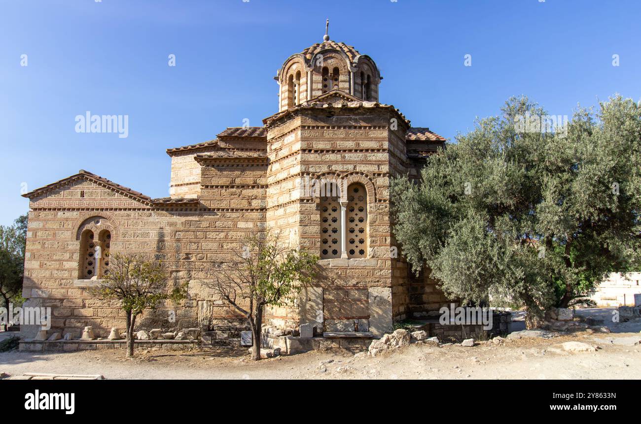 Ancienne église en pierre de style byzantin avec toit en dôme et croix sur le dessus, entourée d'arbres et de chemin à Athènes, Grèce. Photograppin architectural extérieur Banque D'Images