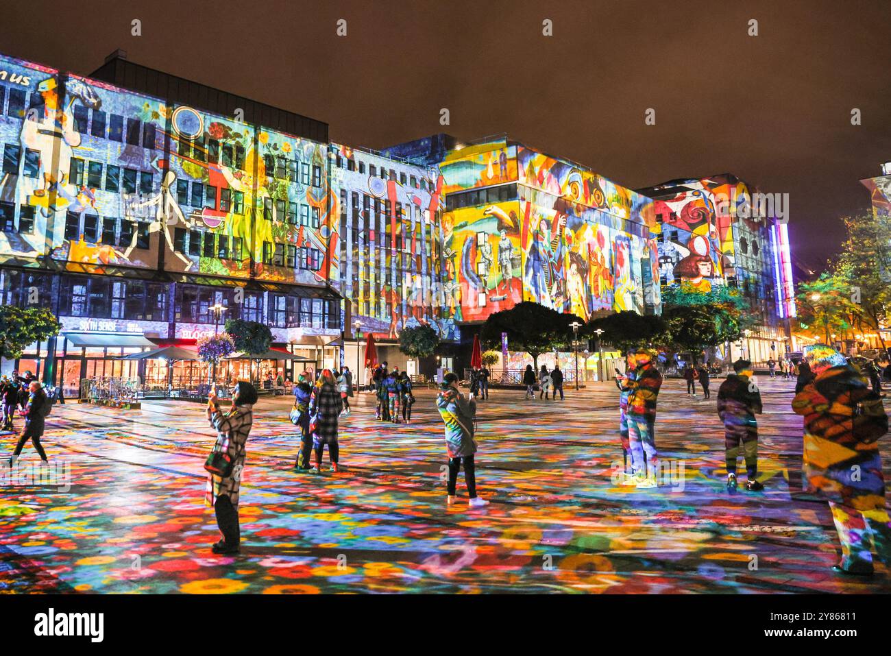 Essen, NRW, Allemagne. 02 octobre 2024. Les visiteurs interagissent avec des œuvres d'art collées du musée Folkswang alors que Kennedy Square est transformé en toile géante dans « Big Picture » de l'artiste berlinois Daniel Margraf, la pièce maîtresse de cette année. Soirée d'ouverture du festival annuel des lumières d'Essen, qui présente 16 grandes installations lumineuses spectaculaires le long d'un parcours de randonnée à travers la ville. Le festival est gratuit et se déroulera tous les soirs du coucher du soleil jusqu’à 23h, du 2 au 13 octobre 2024. Crédit : Imageplotter/Alamy Live News Banque D'Images