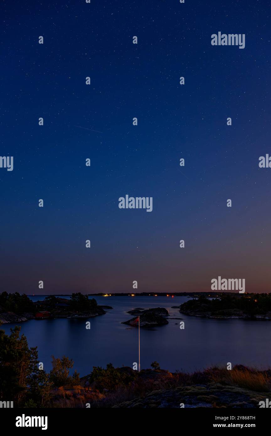 Les étoiles sortent dans un ciel bleu clair de nuit au-dessus de Jomfruland et d'autres îles de l'archipel de Kragerø dans le comté de Telemark, en Norvège. Banque D'Images