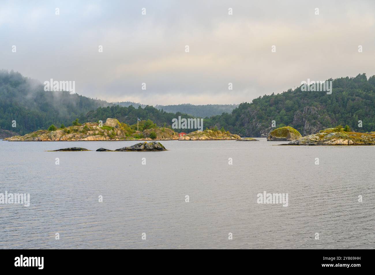 Vue tôt le matin avec nuages bas, brume et lever de soleil sur la mer et skerries à l'île de Gumoy dans l'archipel de Kragero, Telemark Norvège. Banque D'Images