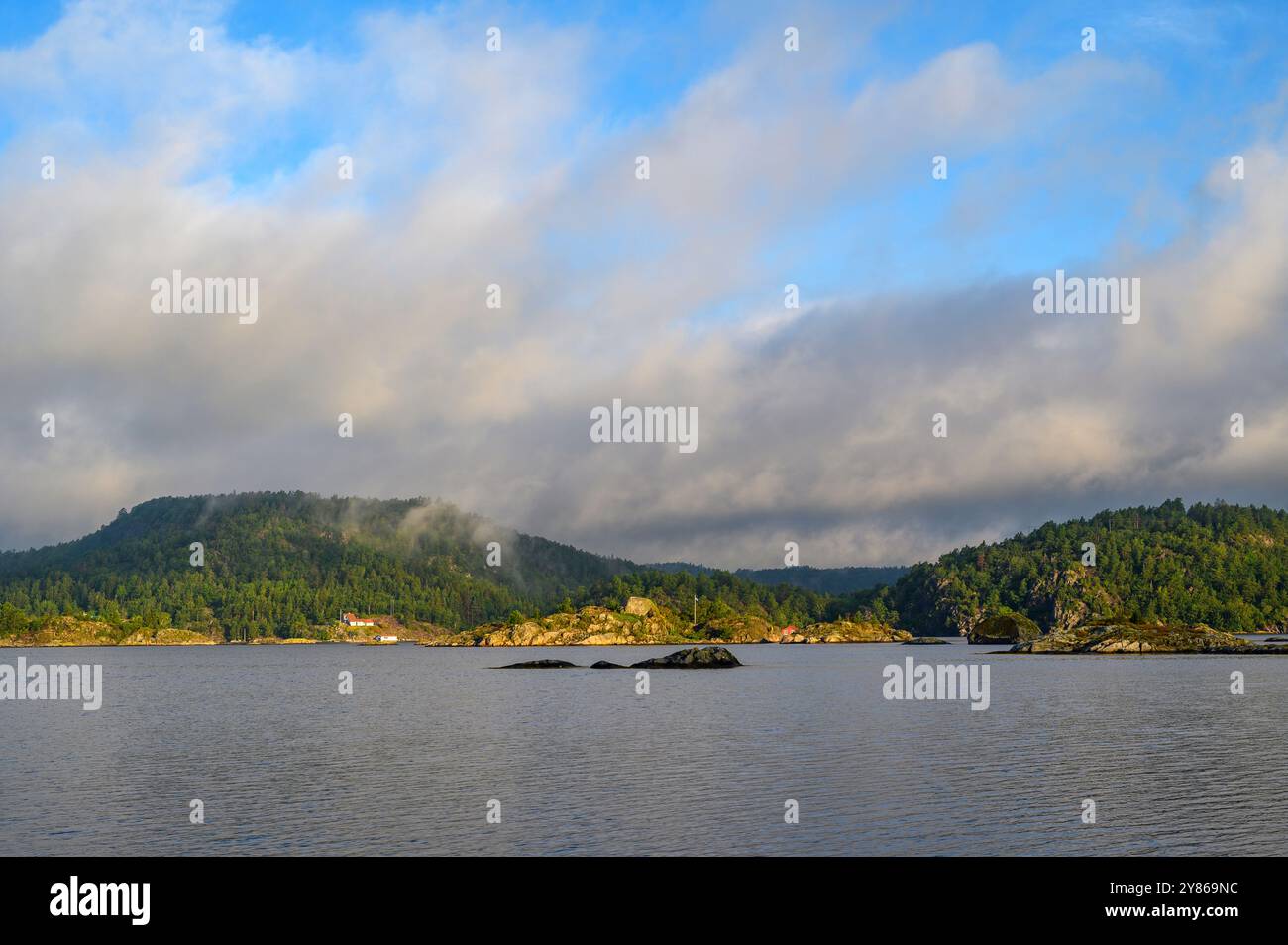 Vue tôt le matin avec nuages bas, brume et lever de soleil sur la mer et skerries à l'île de Gumoy dans l'archipel de Kragero, Telemark Norvège. Banque D'Images