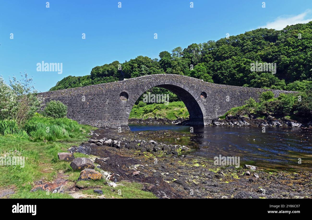 Le pont de Clachan (également connu sous le nom de pont sur l'Atlantique) est un pont de maçonnerie simple, à arc unique, à bosse, enjambant le Clachan Sound, 13 Banque D'Images