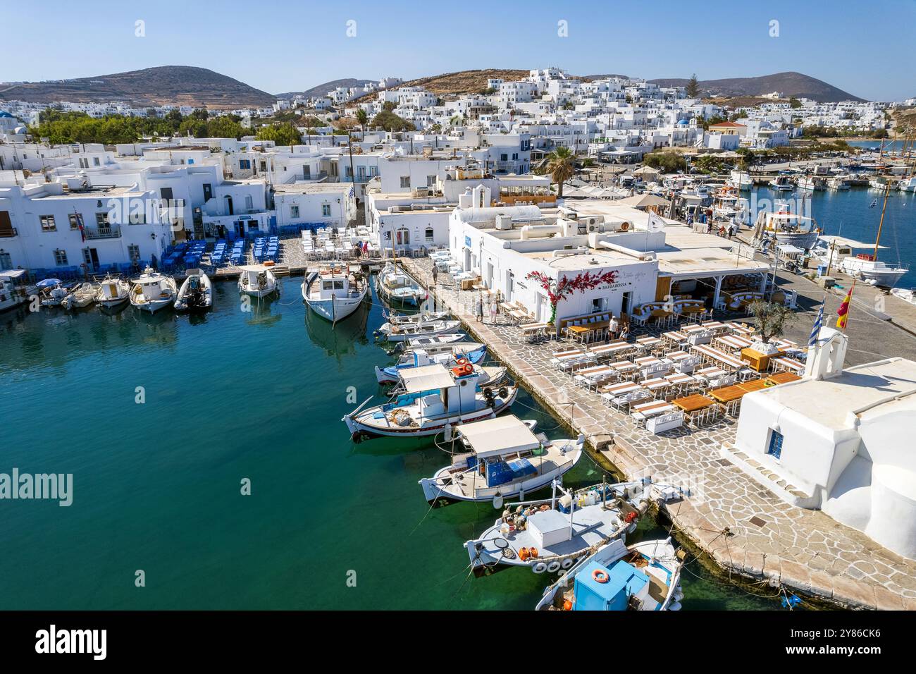 Vue aérienne du port pittoresque de Naousa sur l'île de Paros, en Grèce, avec ses bâtiments traditionnels blanchis à la chaux et ses bateaux de pêche dynamiques Banque D'Images