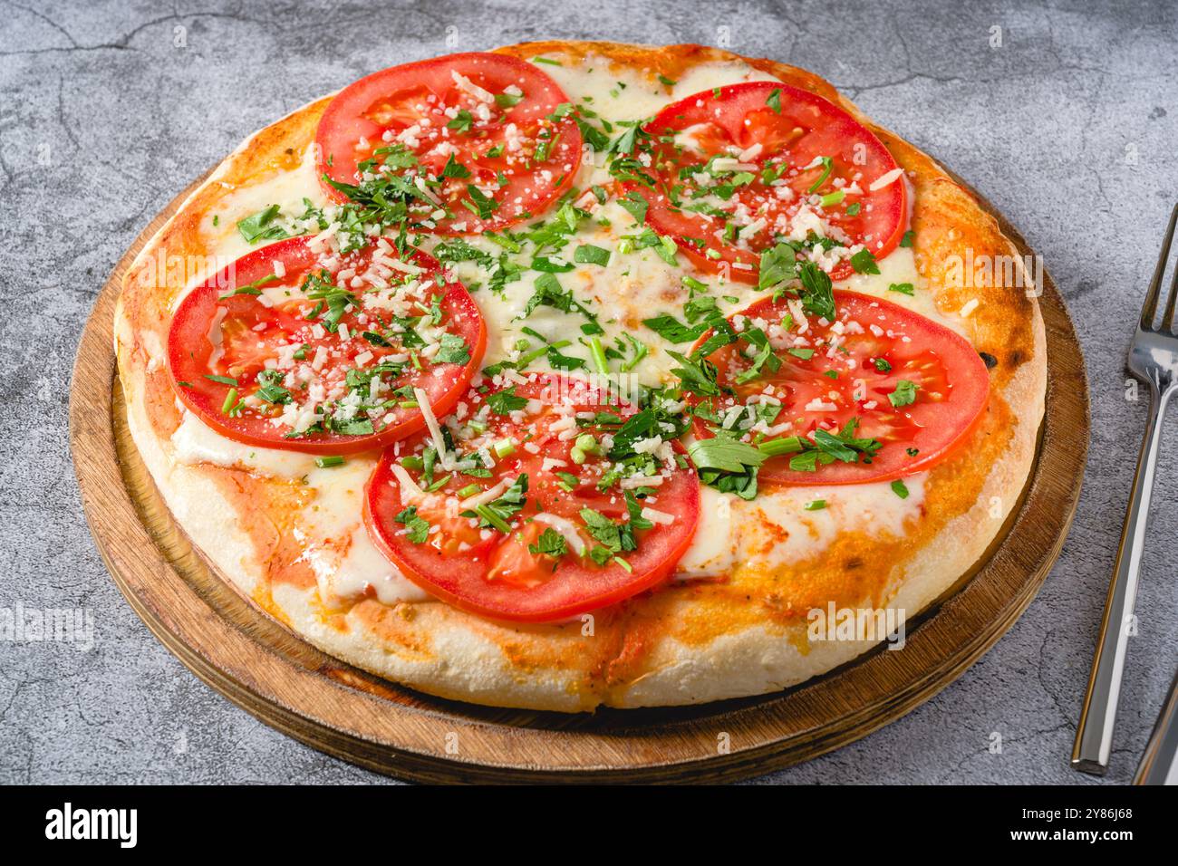 Pizza napolitaine Margherita avec tomates, mozzarella, basilic et olives sur table en pierre Banque D'Images