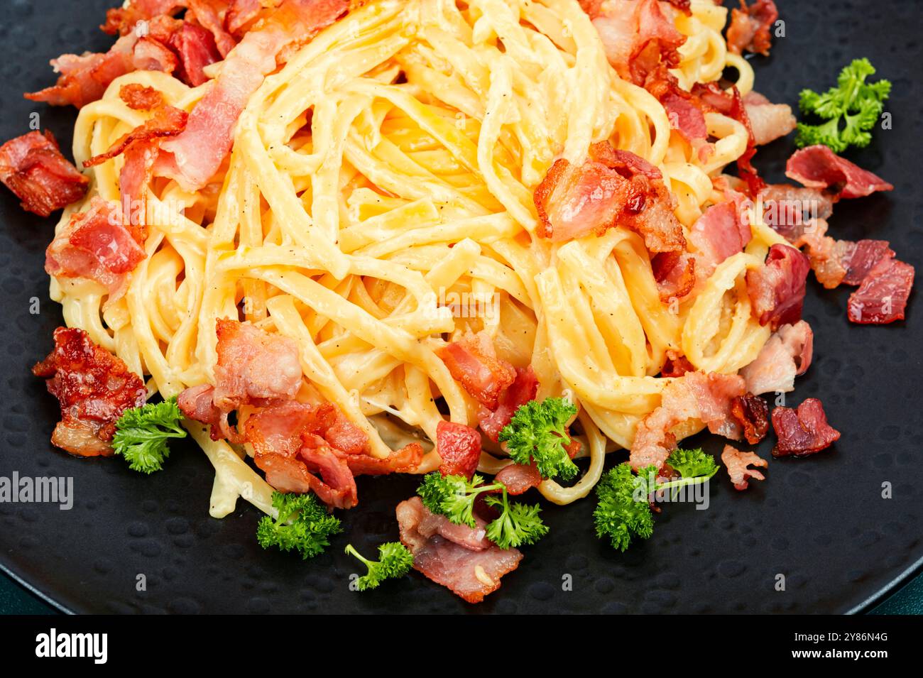 Pâtes maison avec bacon frit sur une assiette, pâtes carbonara. Gros plan. Banque D'Images