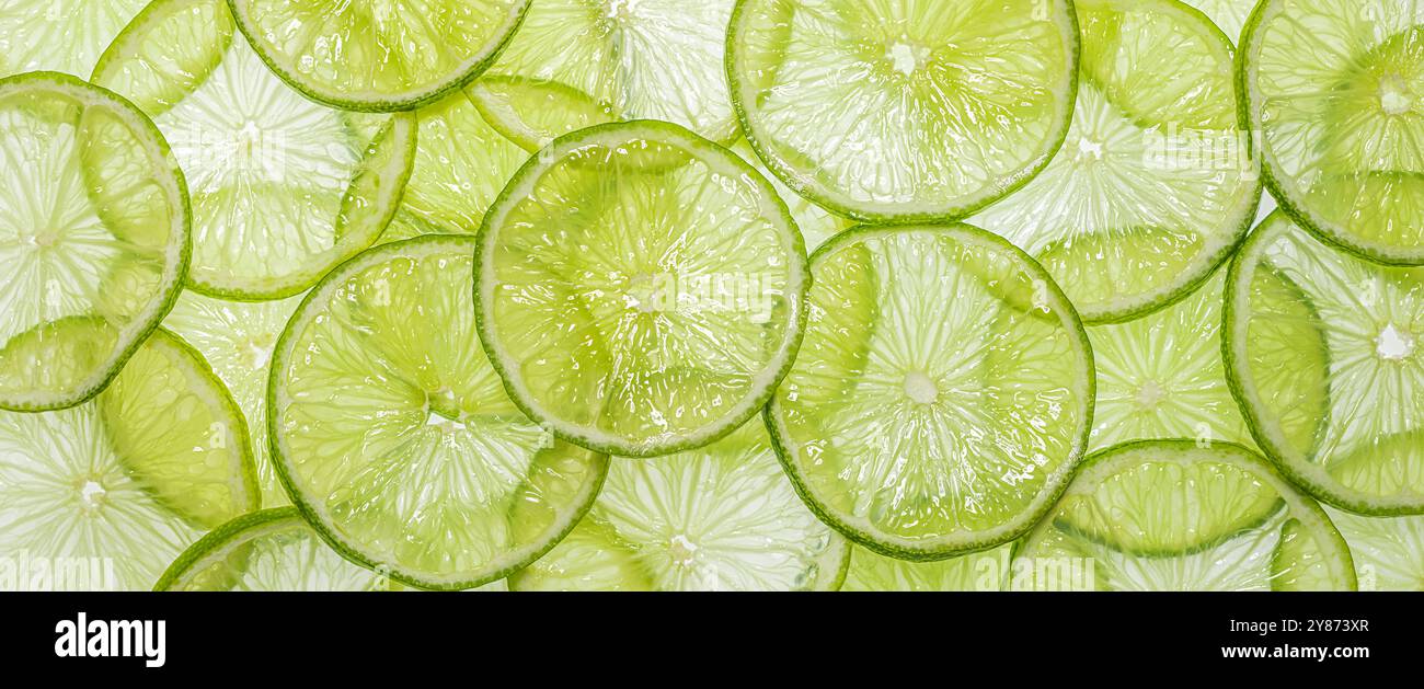 Texture juteuse et couleur verte fraîche des tranches de citron vert sur fond clair Banque D'Images