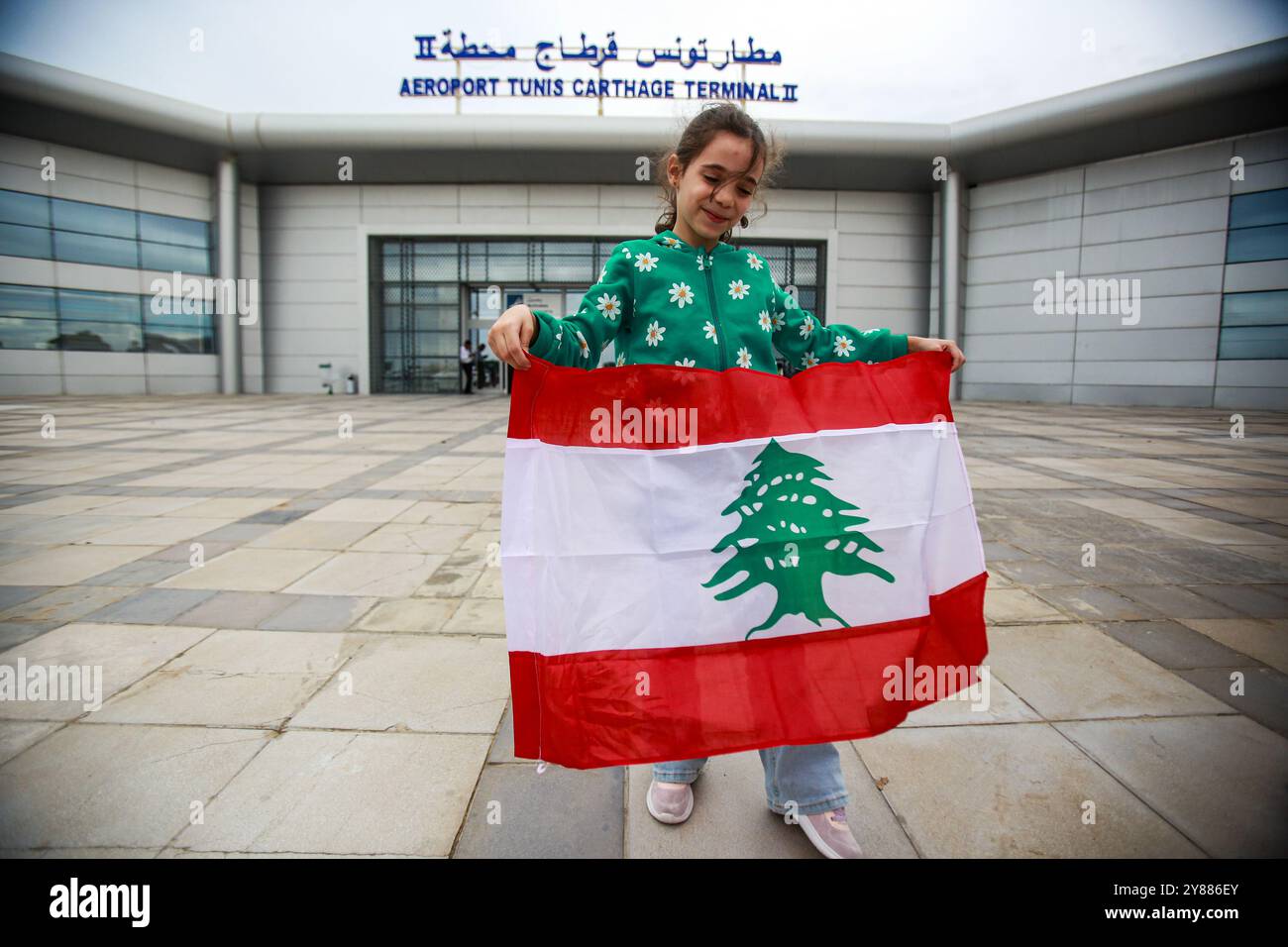 Tunis, Tunisie. 3 octobre 2024. Tunis, Tunisie. 03 octobre 2024. Un enfant arborant le drapeau libanais à l'aéroport de Tunis Carthage lors du retour des Tunisiens dans leur pays depuis le Liban. Des ressortissants étrangers ont fui le Liban jeudi alors que les gouvernements du monde entier exhortaient leurs citoyens à sortir suite à l’intensification des bombardements israéliens de la capitale Beyrouth. Les autorités tunisiennes ont pu évacuer certains de leurs citoyens du Liban malgré un certain retard dans le chaos causé par l'escalade de l'offensive militaire israélienne dans le pays (crédit image : © Hasan Mrad/IMAGESLIVE via ZUMA P Banque D'Images