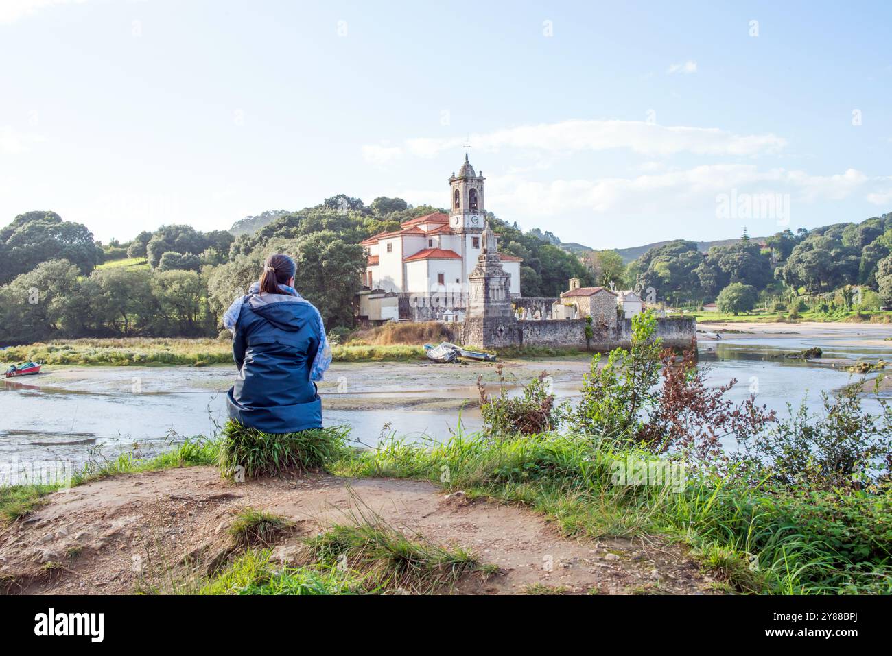 Femme méconnaissable regardant paysage autour de l'église de Nuestra Señora de los Dolores et son cimetière sont situés à Barro, dans le comté asturien Banque D'Images