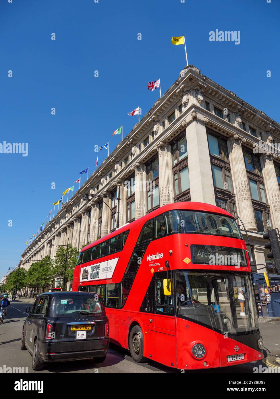 Bus à impériale rouge transport public et taxi noir sur Oxford Street à l'extérieur de Selfridges, Westminster, Londres, Royaume-Uni Banque D'Images