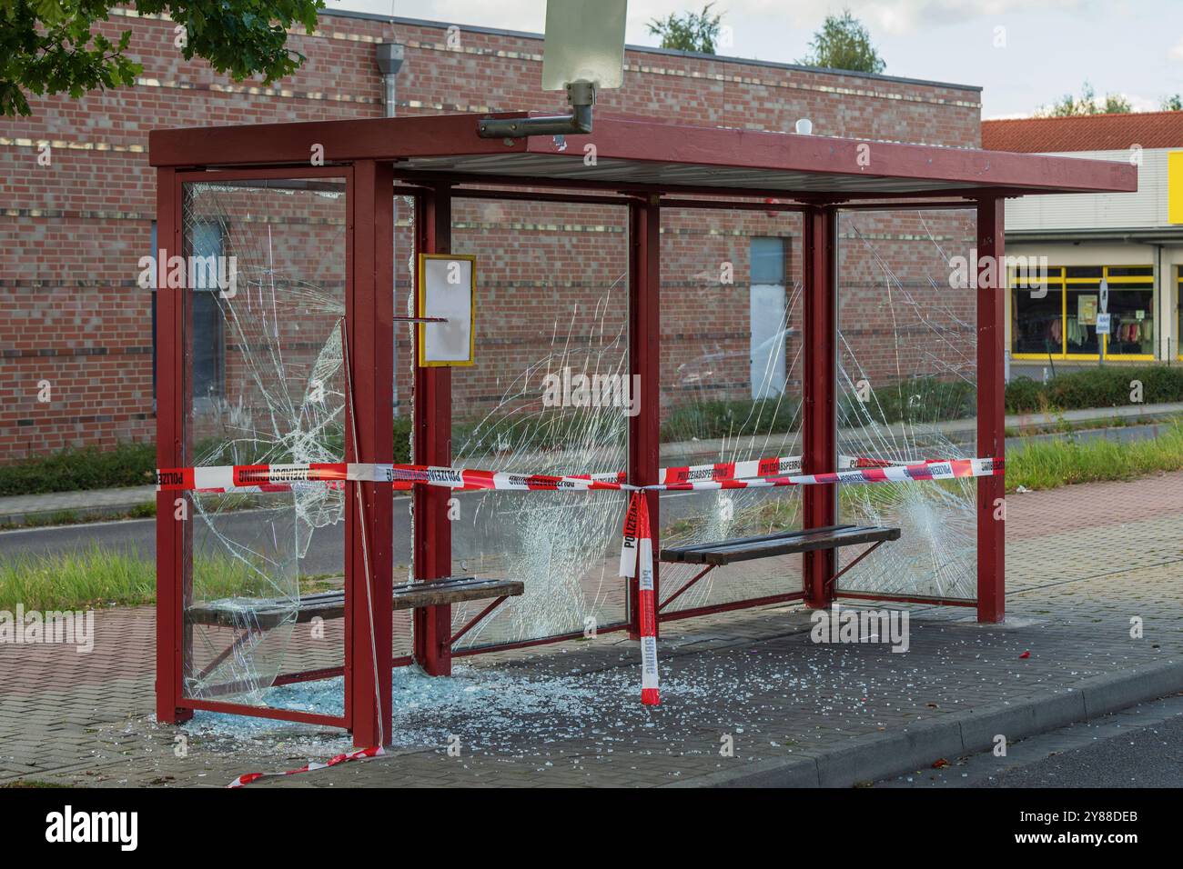 Les fenêtres d'un arrêt de bus ont été brisées et scellées avec une bande de barrière avec l'inscription allemande police spéculation Banque D'Images