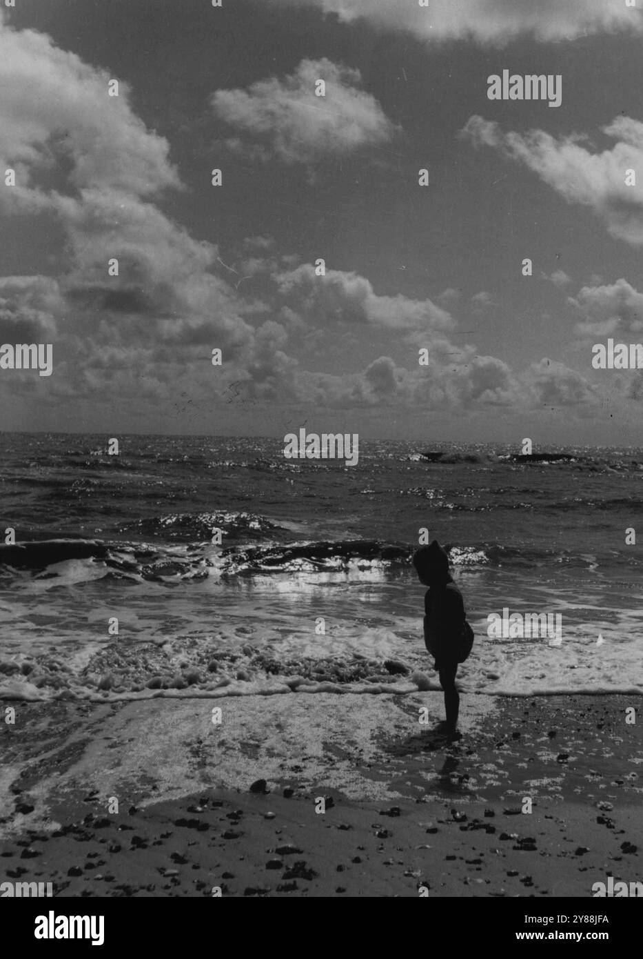 Vacances Sea-side des mineurs. - Silhouette de coucher de soleil : quelque chose de riche et étrange a été apporté dans sa jeune vie par cette mer passionnante. 24 septembre 1951. (Photo de British Official Photograph). Banque D'Images