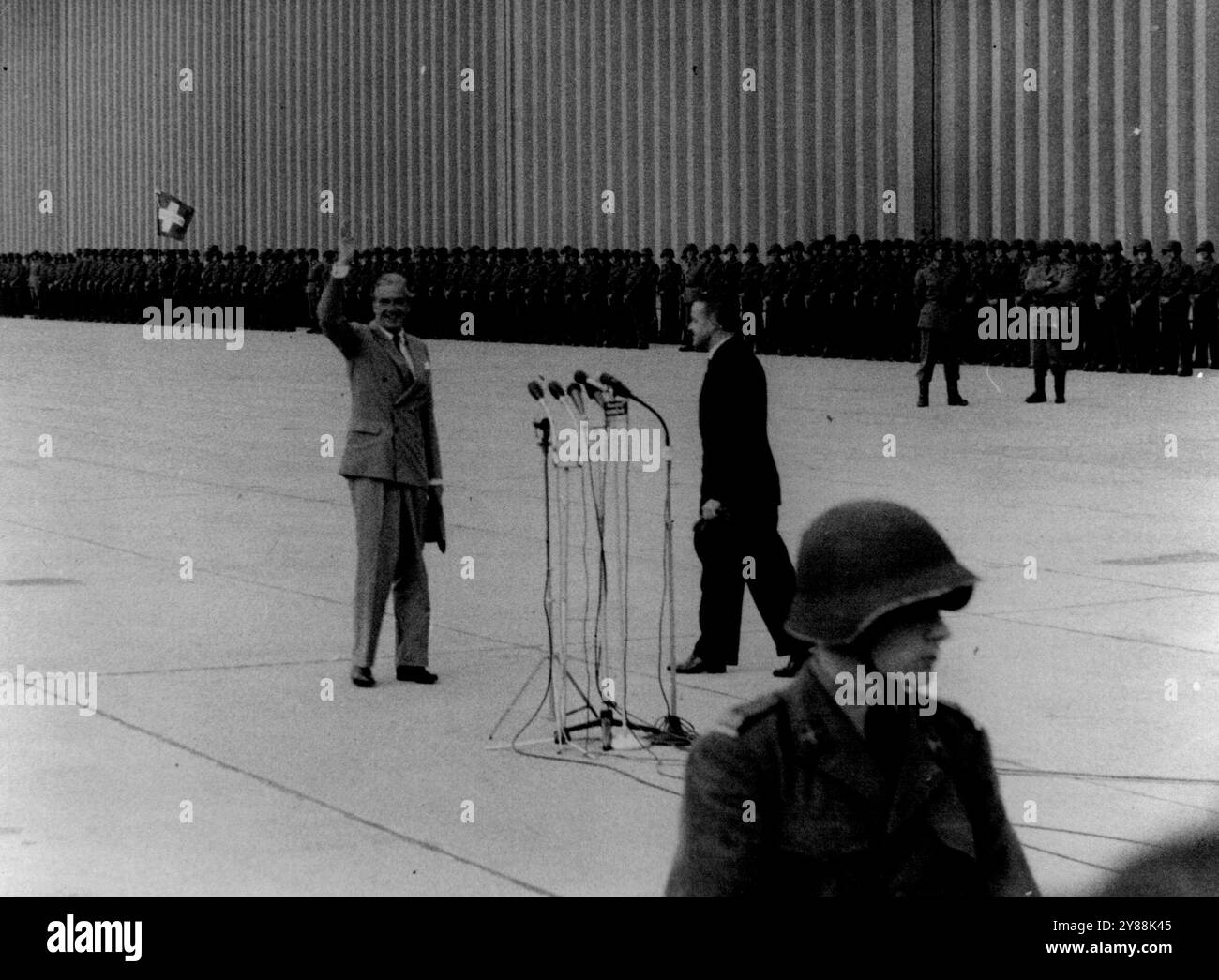 Big four arrivent à Genève - Sir Anthony Eden fait des vagues à la tribune de presse après avoir parlé dans la batterie de microphones peu après son arrivée à l'aéroport de Genève. Il a été rencontré par M. petit-Pierre, président de la confédération suisse. Les trois grands de l'Ouest - Sir Anthony Eden, le président Eisenhower et M. Edgar Faure sont arrivés à Genève hier pour la conférence des quatre grands qui commence demain, 18 juillet. Le premier ministre russe, le maréchal Bulganin, accompagné du secrétaire du parti communiste Krouchtchev, le chef de la défense, le maréchal Zhukov, est arrivé aujourd'hui. Les trois dirigeants occidentaux se réunissent à Genève tod Banque D'Images