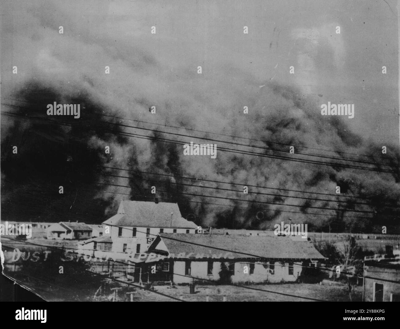 Dust Swallows A Texas Town -- cette photographie remarquable a été faite au Texas alors qu'une tempête de poussière tourbillonnait vers une petite ville à 60 km/h. Quelques minutes après la photo a été prise minuit l'obscurité a couvert la scène et l'air a été rempli de particules de poussière étouffantes et piquantes. 30 juin 1935. (Photo Keystone). Banque D'Images