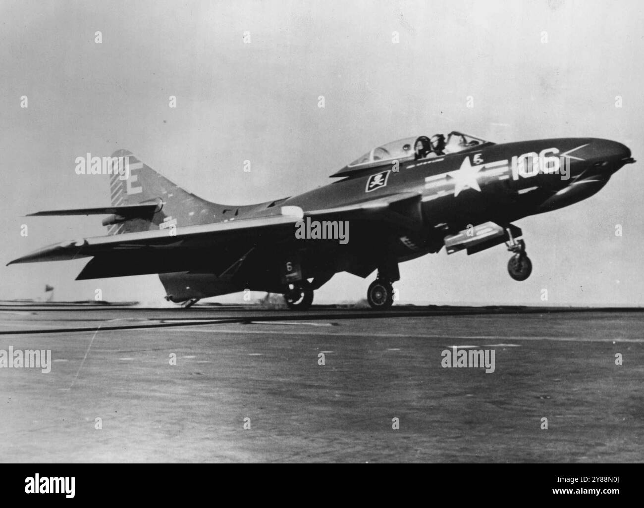 L'amiral américain voit Deck LANDING AID dans H.M.S. Albion - un avion américain F9F Cougar du VF 61 Squadron, U.S.S. Lake Champlain, effectuant un atterrissage en touchand Go sur le pont du H.M.S. Albion, lors d'exercices combinés de la flotte britannique des États-Unis dans l'est de la Méditerranée. Le pilote de l'avion américain a fait usage du nouveau dispositif britannique conçu pour réduire le risque d'accidents à l'atterrissage - l'aide à l'atterrissage par miroir. 18 février 1955. Banque D'Images