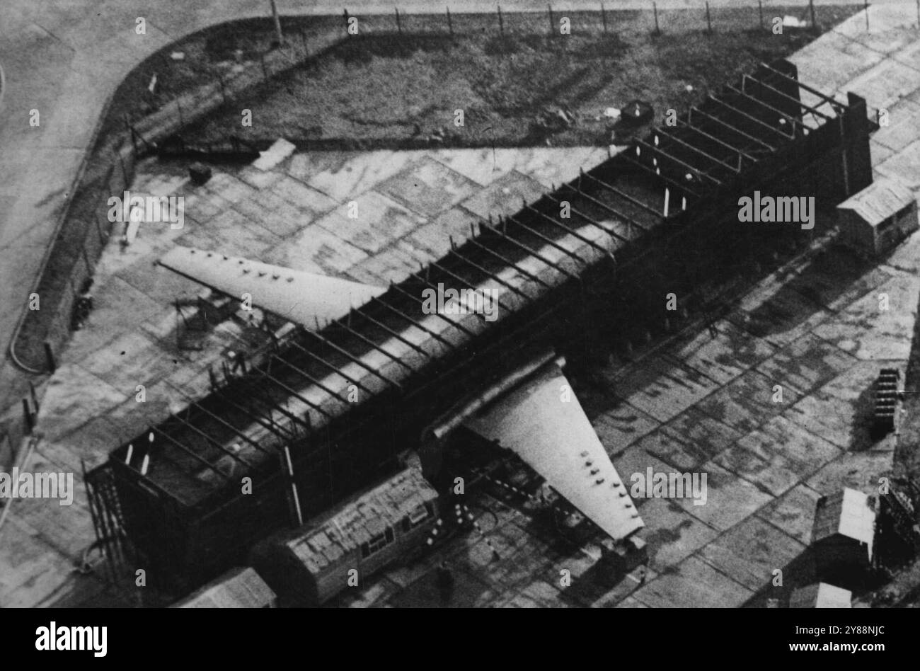 Comet II a le test de réservoir -- L'avion de ligne britannique Comet II subit le test de réservoir d'eau à **** pour prouver la force de son renforcement ***** réservoir a une capacité de 290 000 gallons, et ***** un vol de trois heures peut être simulé en 4 minutes. ***** réservoir toutes les contraintes et les contraintes subies par ***** d'un avion de ligne au cours de sa vie normale ***** reproduit de près en quelques semaines. La photo montre la comète II avec ses ailes en flèche ***** , subissant les tests rigoureux dans le ***** À Hatfield. 19 décembre 1955. Banque D'Images