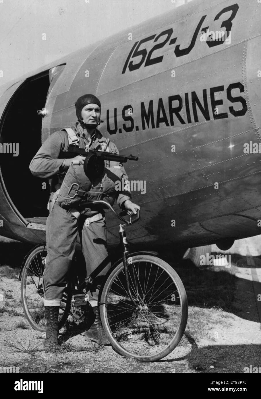 Marine Parachute Troops test Sectional Bicycle - le soldat Douglas Boyd, de porter, Okla., un parachutiste marin, démontre comment il s'éloignerait avec un canon Tommy dans le territoire «ennemi» après que le vélo de section IS a été mis en place après un saut avec elle d'un avion. Les Marines essaient l'utilisation du vélo sectionnel pour les troupes de parachute comme une idée purement expérimentale. Dans la pratique, il n'aurait pas le parachute sur le dos parce qu'il l'aurait déjà utilisé pour atterrir. 18 septembre 1941. (Photo ACME). Banque D'Images
