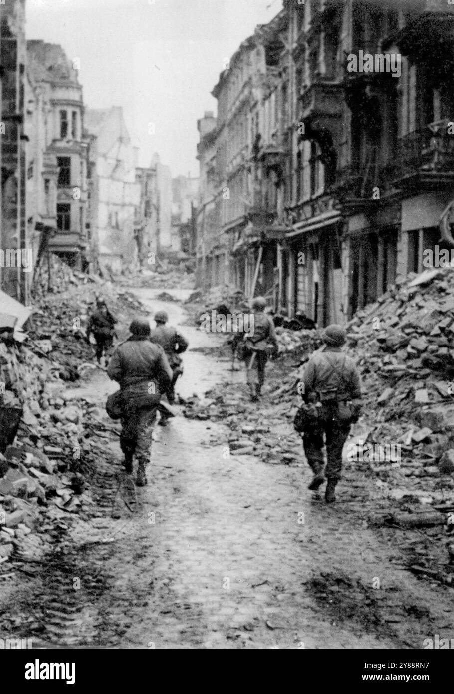 À travers les ruines de Bonn - les fantassins américains se fraient un chemin à travers l'une des nombreuses rues sinueuses de Bonn, ville allemande sur le Rhin et mondialement connue pour son université, et comme le lieu de naissance de Beethoven. 21 mai 1945. Banque D'Images