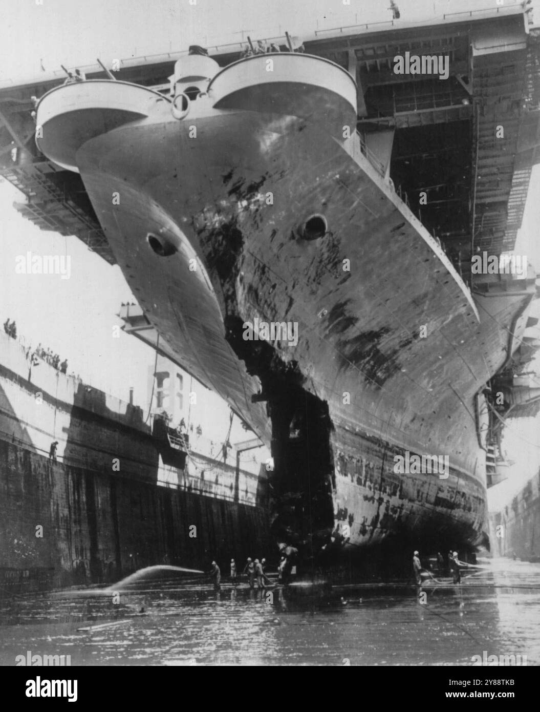 Masque de la mort -- les trous d'aubes du porte-mines Wasp apparaissent comme des yeux effrayés regardant vers le bas une bouche endommagée de l'engin qui est entré en collision au milieu de l'Atlantique avec le destroyer-dragueur Hobson hier alors que le navire était amarré en cale sèche ici pour réparations. Les travaux de réparation devraient prendre trois semaines. La tragédie océanique a coûté la vie à 176 personnes. 9 mai 1952. (Photo de AP Wirephoto). Banque D'Images