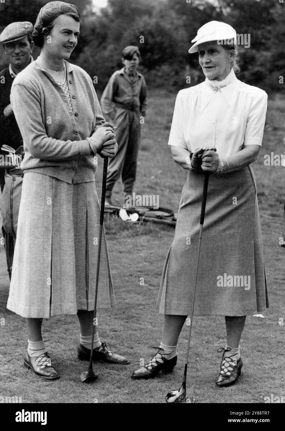 Porter un chapeau blanc à pointe **** Match sa blouse, Lady Astor (à droite) discute avec MRS Malcolm McCorquodale lors du 26e match annuel Lords versus Commons de l'association parlementaire de golf féminine sur ce parcours de surrey. 24 juin 1948. Banque D'Images