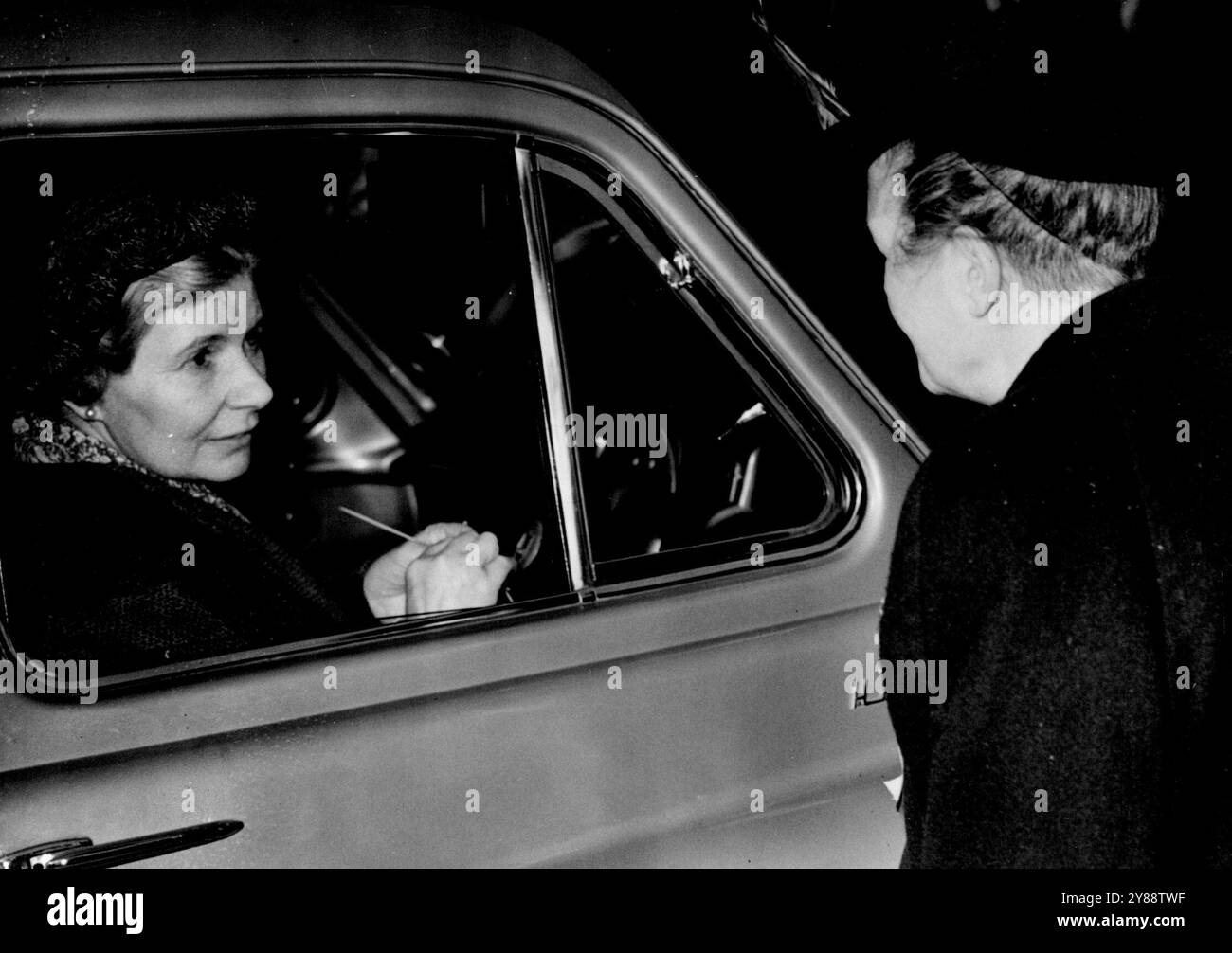 MRS Attlee conduit des sondages de premier Round -- tricot alors qu'elle attend au volant de sa voiture, MRS Attlee discute avec un bon ami au bureau de vote de Coppermill Road School. Le député Attlee conduisait le premier ministre à visiter les bureaux de vote de sa circonscription de Walthamstow Ouest. 25 octobre 1951. Banque D'Images