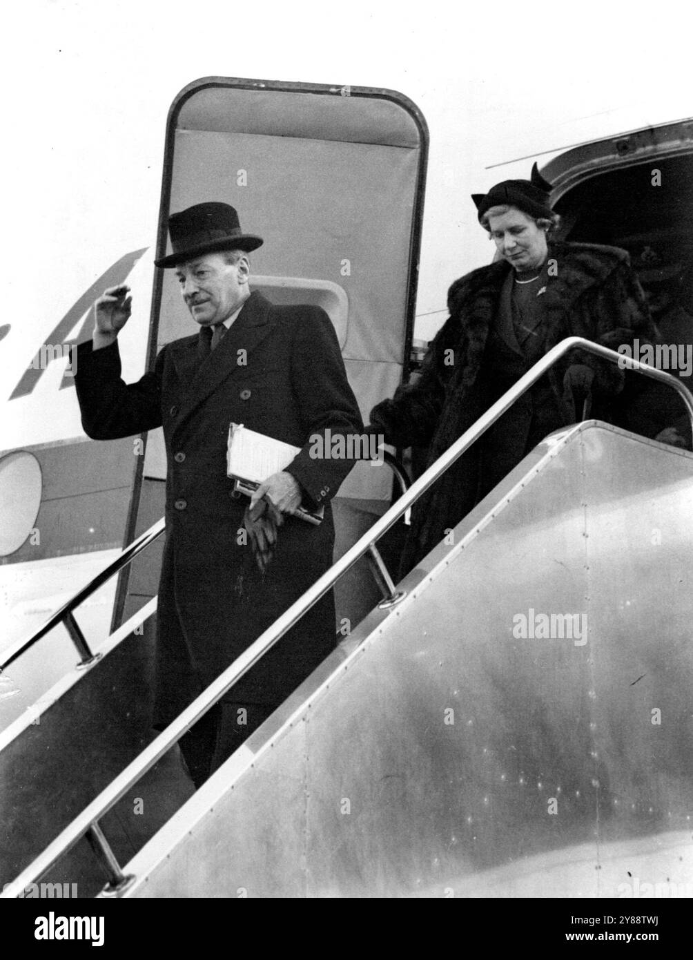 Attlee Home -- M.Attlee quittant l'avion à son arrivée à l'aéroport de Londres aujourd'hui suit sa femme, qui l'a accueilli. M. Clement Attlee, le premier ministre, est arrivé à l'aéroport de Londres par B.O.A.C. Stratociuiser de New York aujourd'hui (mardi) à son retour chez lui après ***** À Washington et Ottawa. 12 décembre 1950. (Photo de Reuterphoto). Banque D'Images