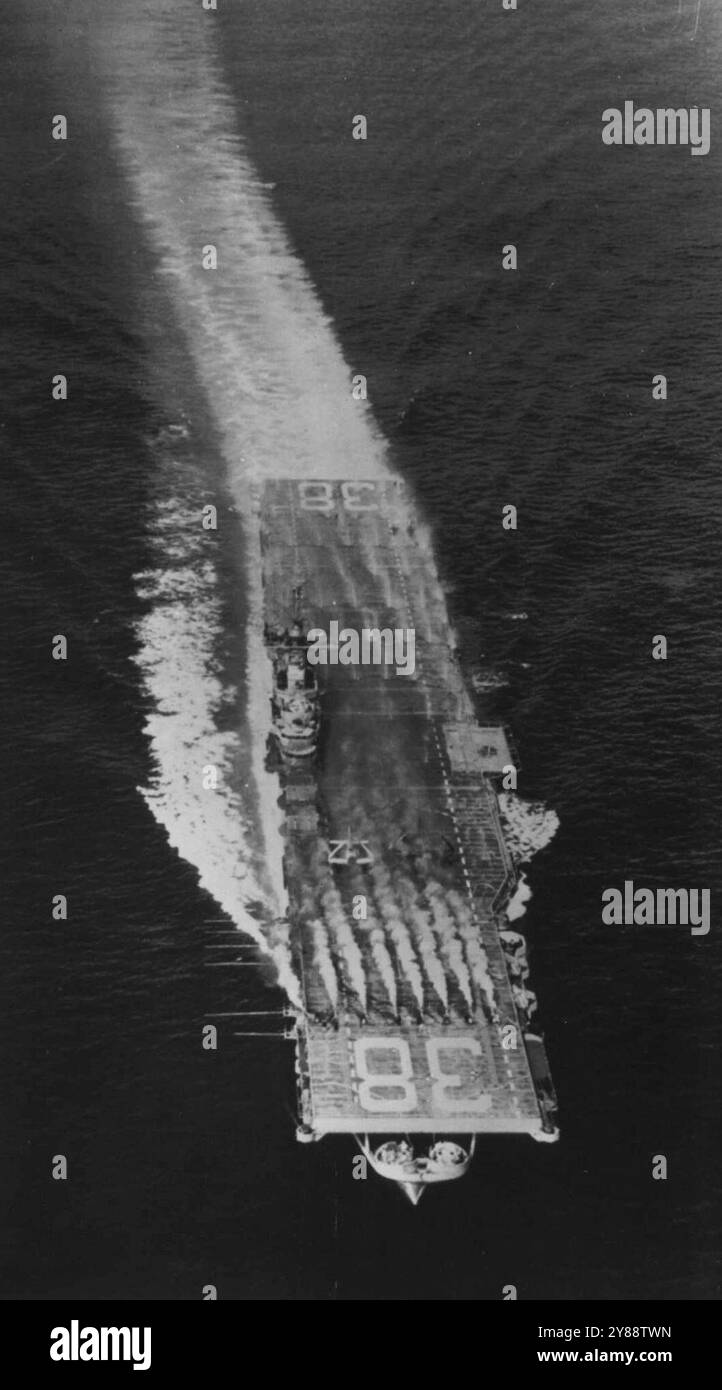 Porteur dans l'essai de défense atomique -- le porteur Shangri-la subit un essai au large d'Atlantic City, N.J., en juillet 1952, d'un système de gicleurs extérieur conçu pour laver des quantités invalidantes de retombées radioactives d'une explosion nucléaire. De la vapeur colorée est versée sur le navire à partir de ventilateurs montés à l'avant sur le pont d'envol. Dans le même temps, l'eau est pulvérisée sur le pont et la superstructure à partir de gicleurs. L'eau a lavé le colorant -- simulant des particules de rayonnement -- dans la mer. Le système de gicleurs a subi un test imprévu lorsque plusieurs navires de la marine ont été pris dans les retombées de l'Hydr du 1er mars Banque D'Images