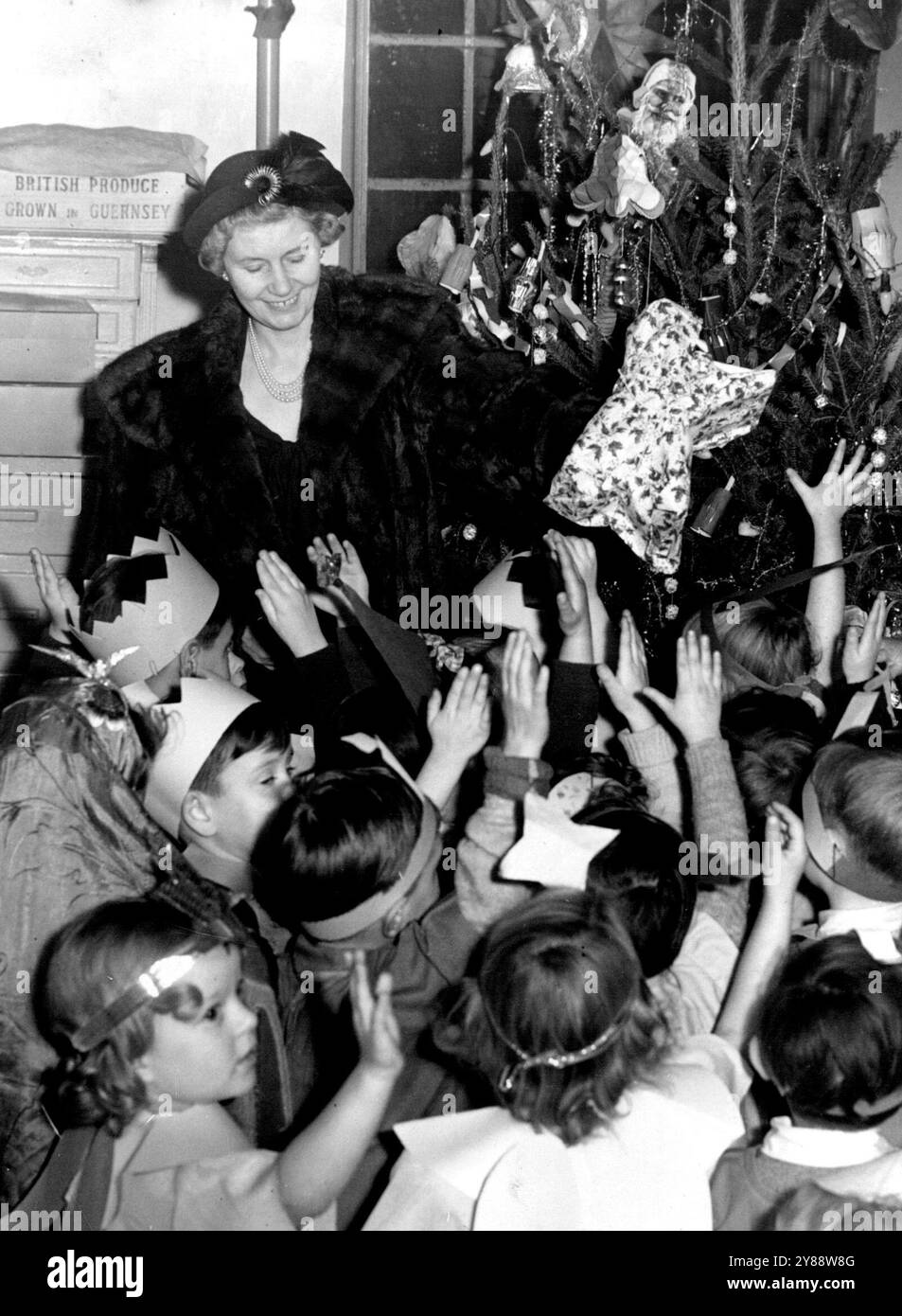La femme du premier ministre joue le Père Noël à la fête des enfants -- de minuscules mains avides sont levées alors que MRS Attlee, l'épouse du premier ministre, distribue des cadeaux de l'arbre de Noël lors d'une fête à la North Islington Nursery School, à Finsbury Park. Environ 40 enfants âgés de trois à cinq ans ont assisté à la fête, et ils ont diverti MRS Attlee avec des chants. 18 décembre 1950. Banque D'Images