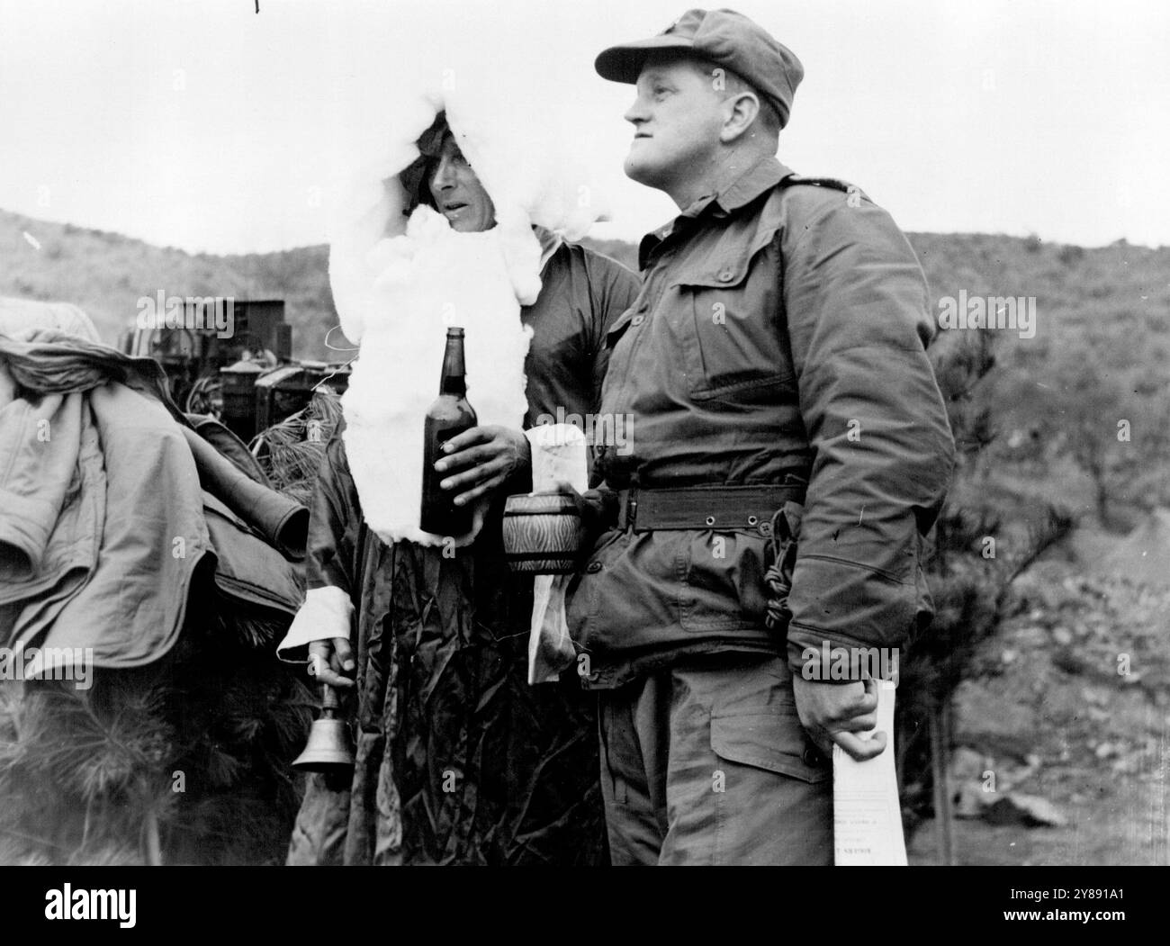 Avec l'australien en Corée -- le commandant du 1er Bataillon, Royal Australian Regiment, le lieutenant-colonel M. Austin, de Devonport, tas, (à droite) et L'ADJ R.O. McLaughlin, qui a agi en tant que Père Noël, partagent quelques rafraîchissements aux festivités de Noël du Bataillon qui ont eu lieu le jour de l'an alors que le Bataillon était en ligne le jour de Noël. 1er janvier 1953. (Photo de l'armée australienne photo). Banque D'Images