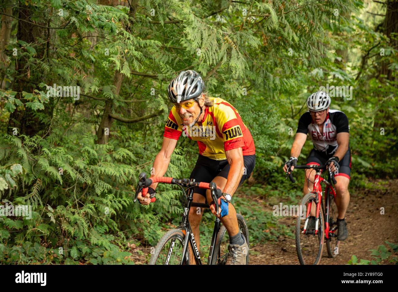 WA25648-00...WASHINGTON - les coureurs Cyclocross parcourent une rare section de sentier à travers la forêt à Silver Lake. Banque D'Images