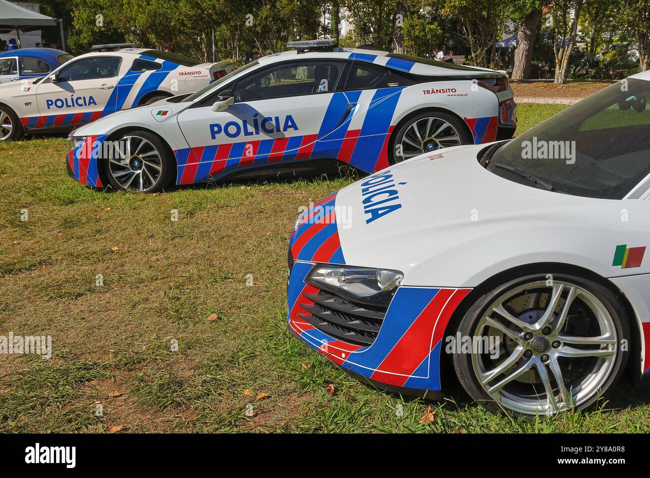 Rangée de voitures de police portugaises sont garées sur l'herbe, mettant en valeur leur design de livrée bleu et rouge distinctif Banque D'Images