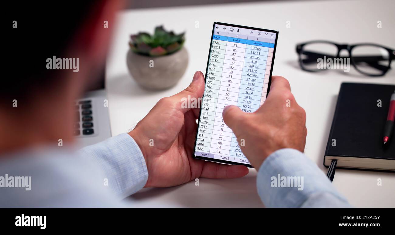 Analyste de données de feuille de calcul utilisant un logiciel informatique sur téléphone Banque D'Images