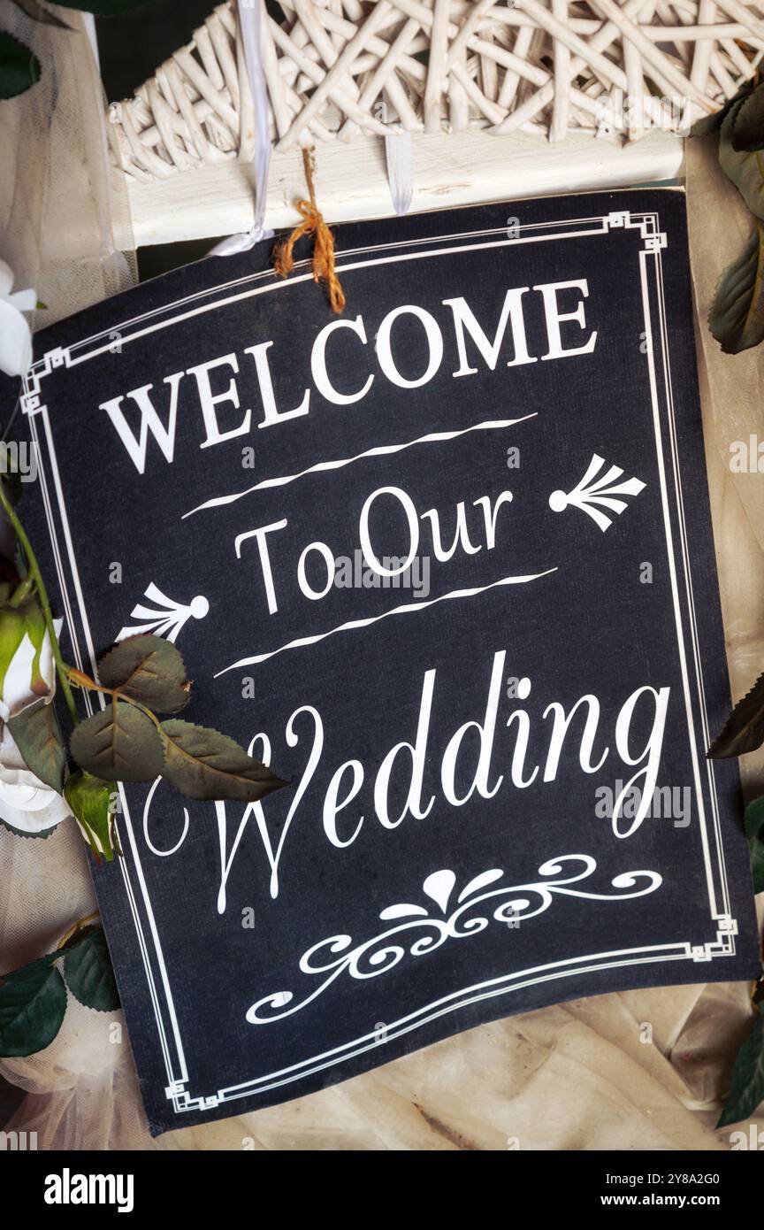 Annonce de mariage sur panneau noir avec lettrage blanc suspendu à une décoration en osier blanc Banque D'Images