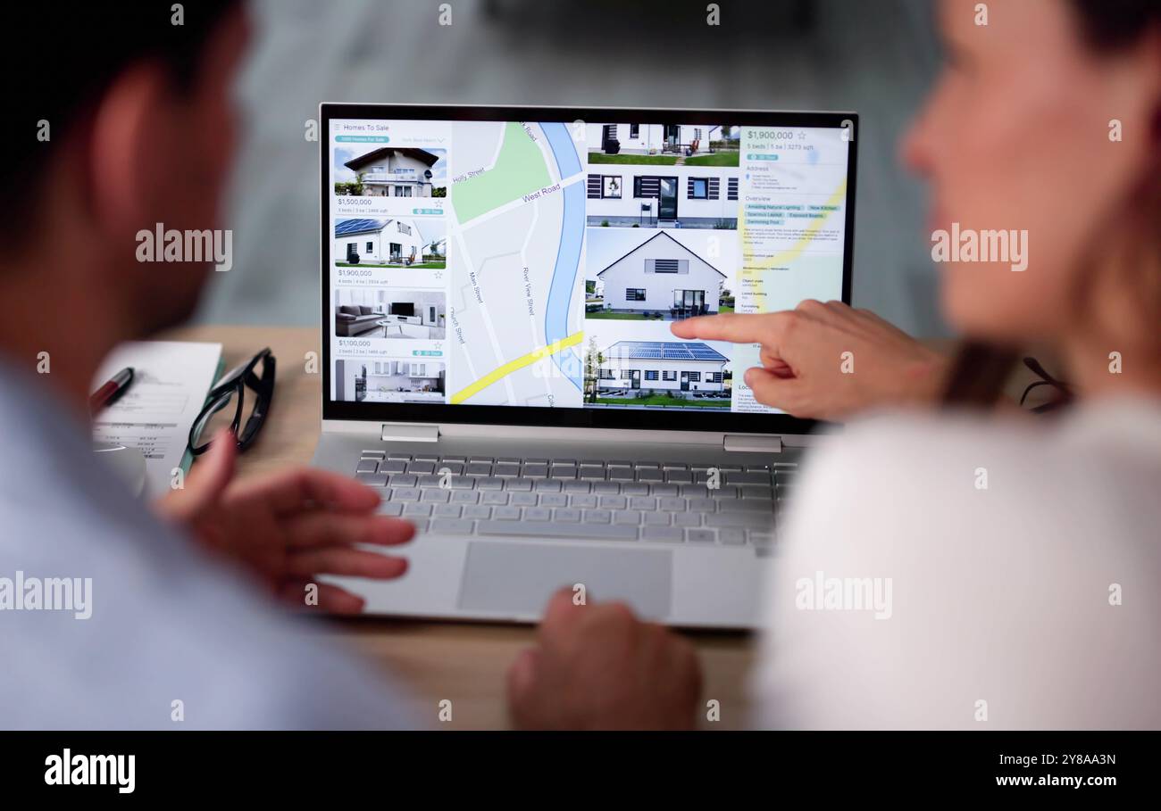 Couple famille recherche Immobilier en ligne sur ordinateur portable Banque D'Images