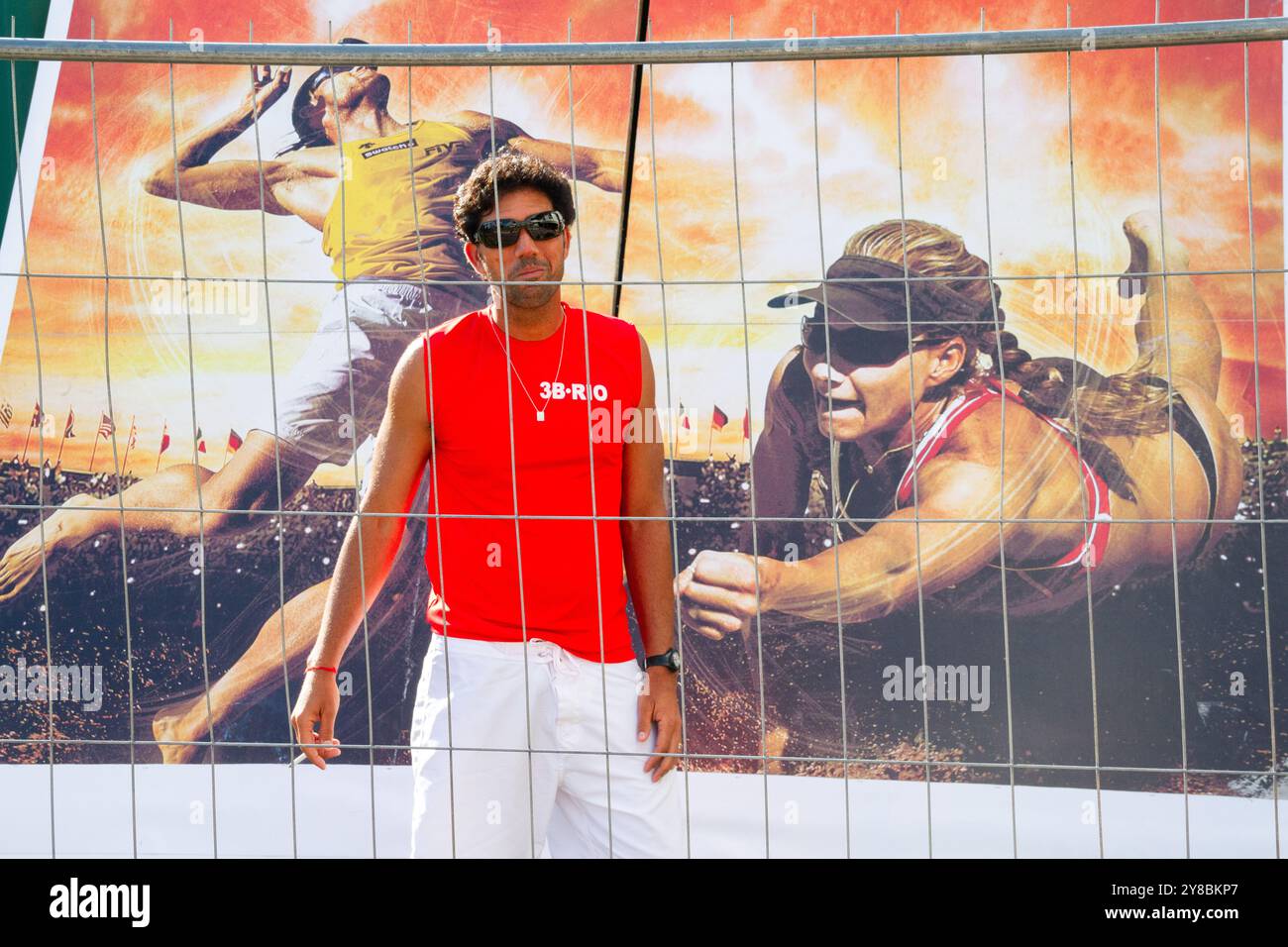 ENTRAÎNEUR REGARDANT L'ACTION, BEACH VOLLEY, MARIEHAMN, 2011 : un entraîneur regarde l'action de volley à travers une clôture en août 2011 à l'Open de la PAF à Mariehamn, Åland, Finlande. Photographie : Rob Watkins. INFO : entre 2009-2013, le tournoi PAF Open Beach Volleyball était un événement annuel organisé à Mariehamn, Åland, Finlande. Il a attiré les meilleures équipes et joueurs internationaux dans le cadre du circuit mondial officiel de la FIVB, mettant en vedette le Beach volley de haut niveau. Banque D'Images