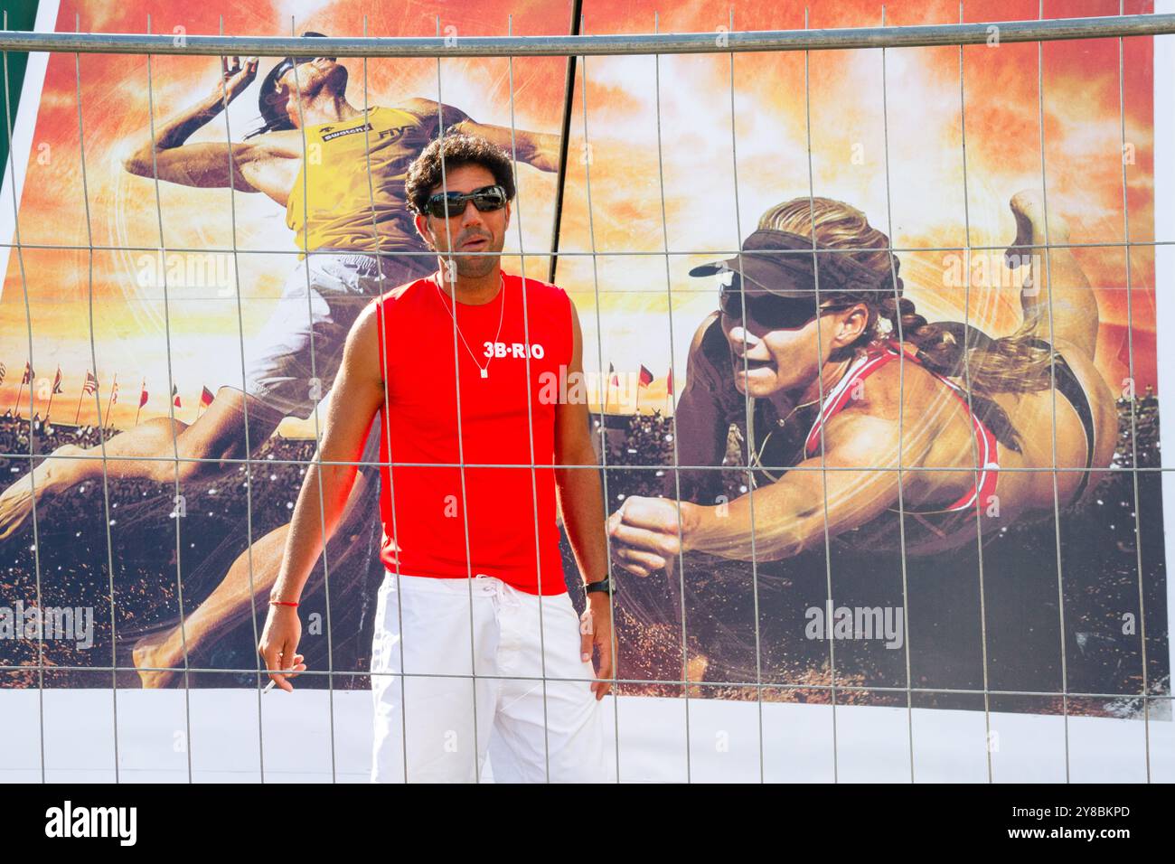 ENTRAÎNEUR REGARDANT L'ACTION, BEACH VOLLEY, MARIEHAMN, 2011 : un entraîneur regarde l'action de volley à travers une clôture en août 2011 à l'Open de la PAF à Mariehamn, Åland, Finlande. Photographie : Rob Watkins. INFO : entre 2009-2013, le tournoi PAF Open Beach Volleyball était un événement annuel organisé à Mariehamn, Åland, Finlande. Il a attiré les meilleures équipes et joueurs internationaux dans le cadre du circuit mondial officiel de la FIVB, mettant en vedette le Beach volley de haut niveau. Banque D'Images