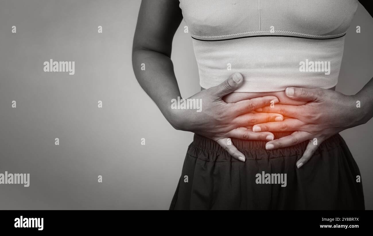 Femme mains sur l'estomac douloureux souffrant de maux d'estomac, symptôme de maladie. Stress, menstruation, diarrhée, problème digestif, cancer du col de l'utérus, CR Banque D'Images